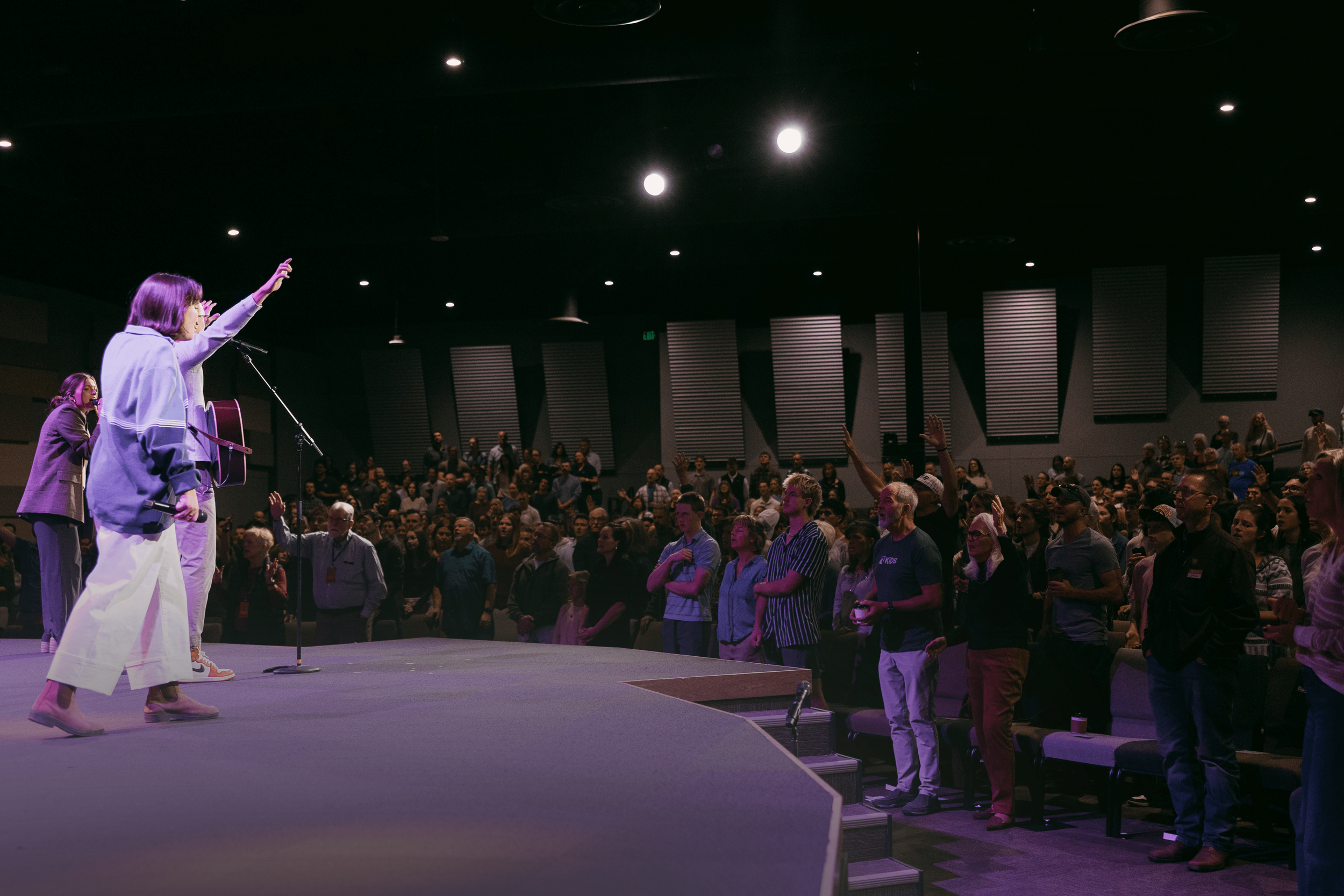 Group of diverse people playing hand game outdoors, smiling and high-fiving each other during daytime.