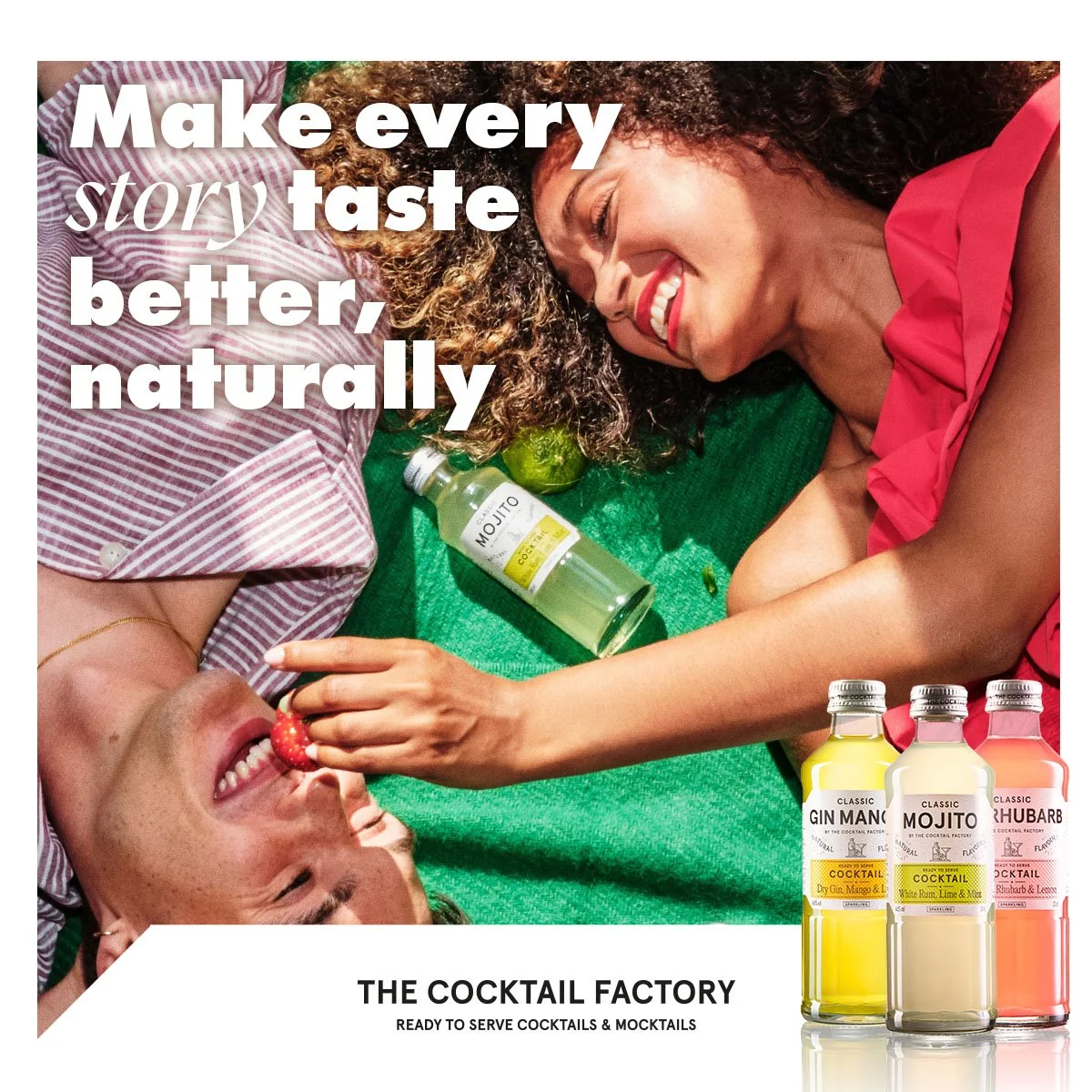 To glade personer nyder cocktails på en picnic-tæppe. En kvinde fodrer en mand med en jordbær. Der er tre cocktailsflasker i forgrunden, mærket Gin Mango, Mojito og Rhubarb.