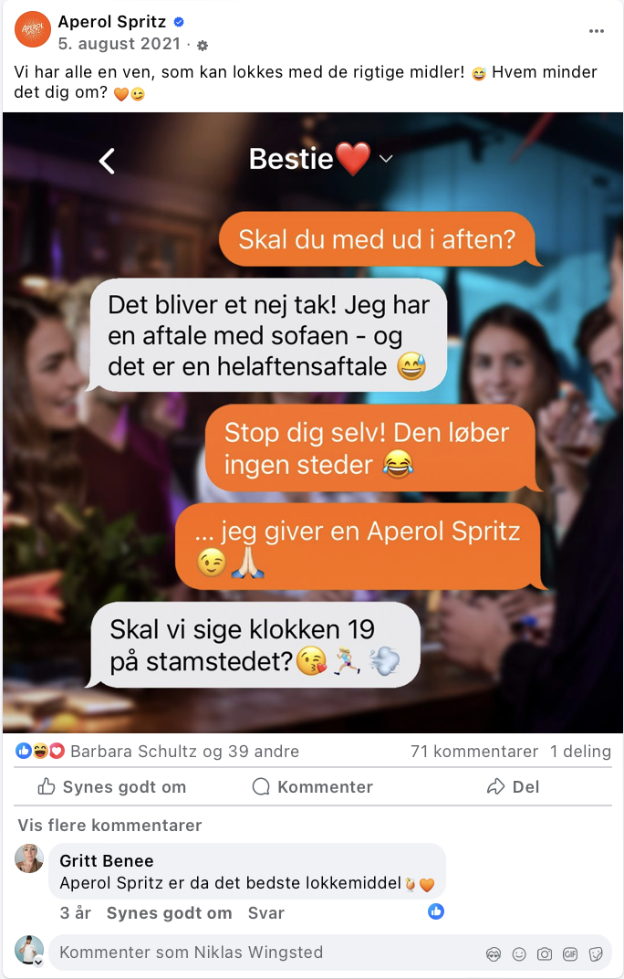 En gruppe mennesker til en fest, hvor nogle sidder rundt om et bord med drinks og hyggesnakker, mens de andre står i baggrunden. Der er stemning og lys i baggrunden.