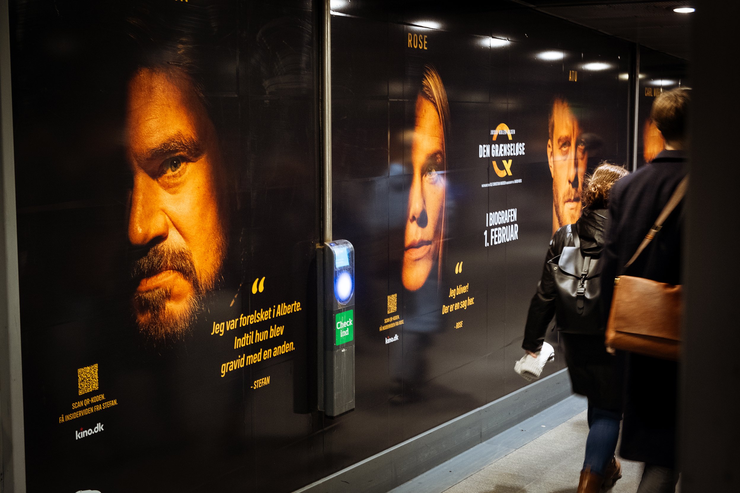 Reklametavler for filmen 'Den Grænselelse' på en metrostation, med billeder af tre karakterer og tekst om filmens biografpremiere den 1. februar.