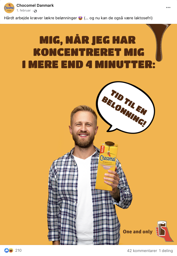 En smilende mand holder en Chocomel-flaske mod baggrunden, der er orange. Der er en tekstboble med teksten 'Tid til en belønning!'. Overskriften siger 'Mig, når jeg har koncentreret mig i mere end 4 minutter:'