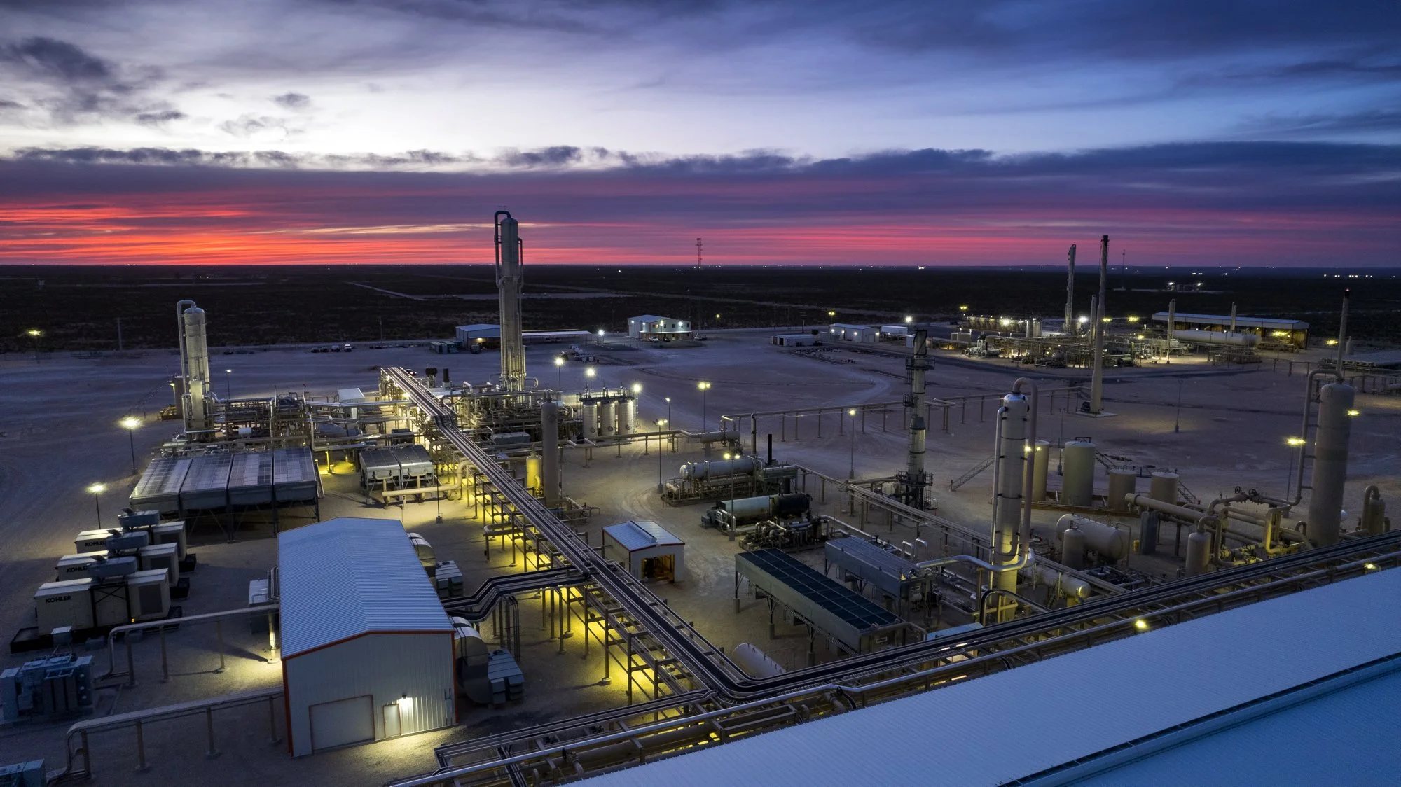 Oil refinery at sunset with industrial equipment and pipelines