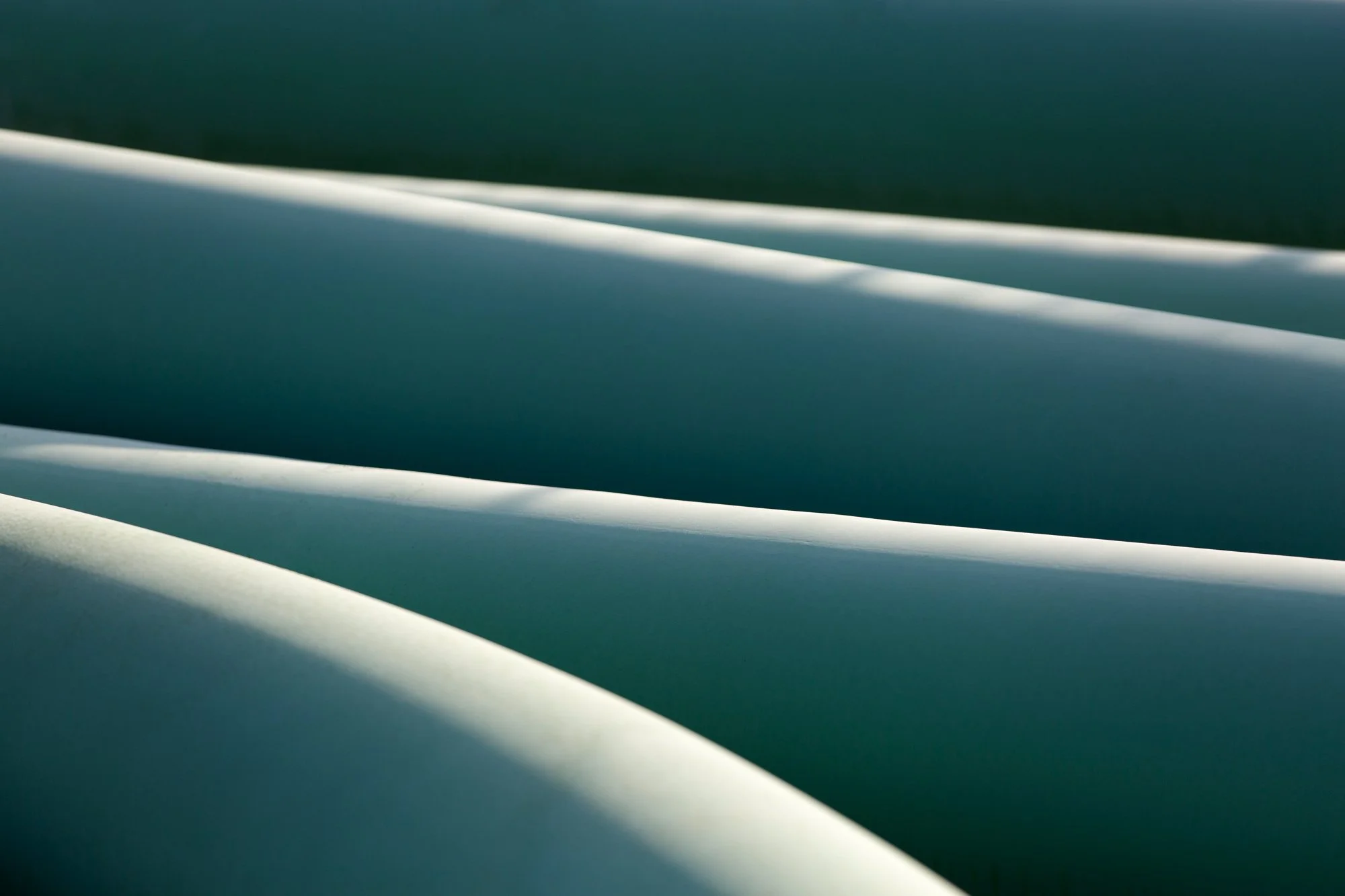 Close-up of smooth, white, curved structures, possibly architectural or industrial elements, with soft shadows and gradients.
