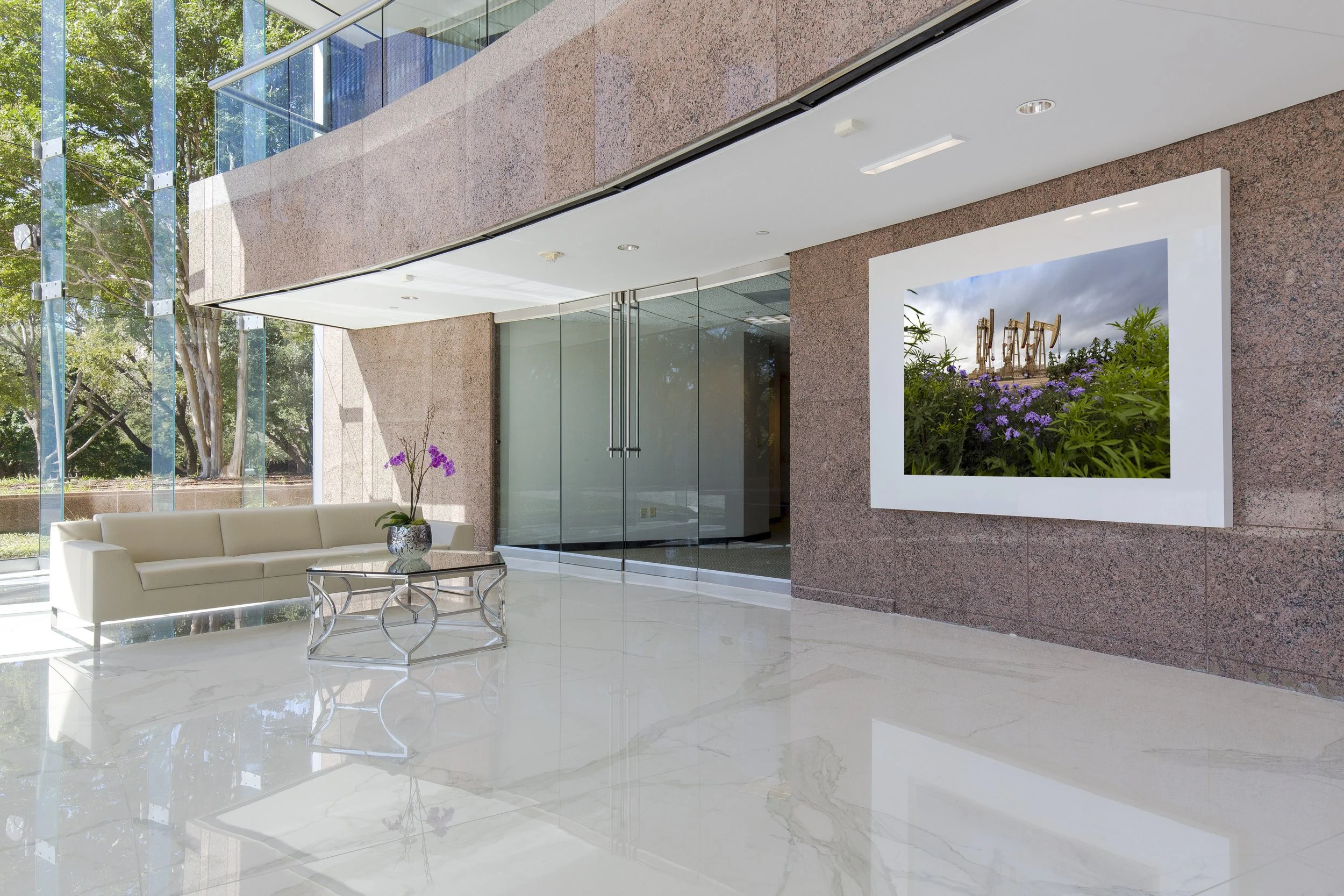 Framed photograph of a desert landscape with mountains in the background, displayed on a plain wall.