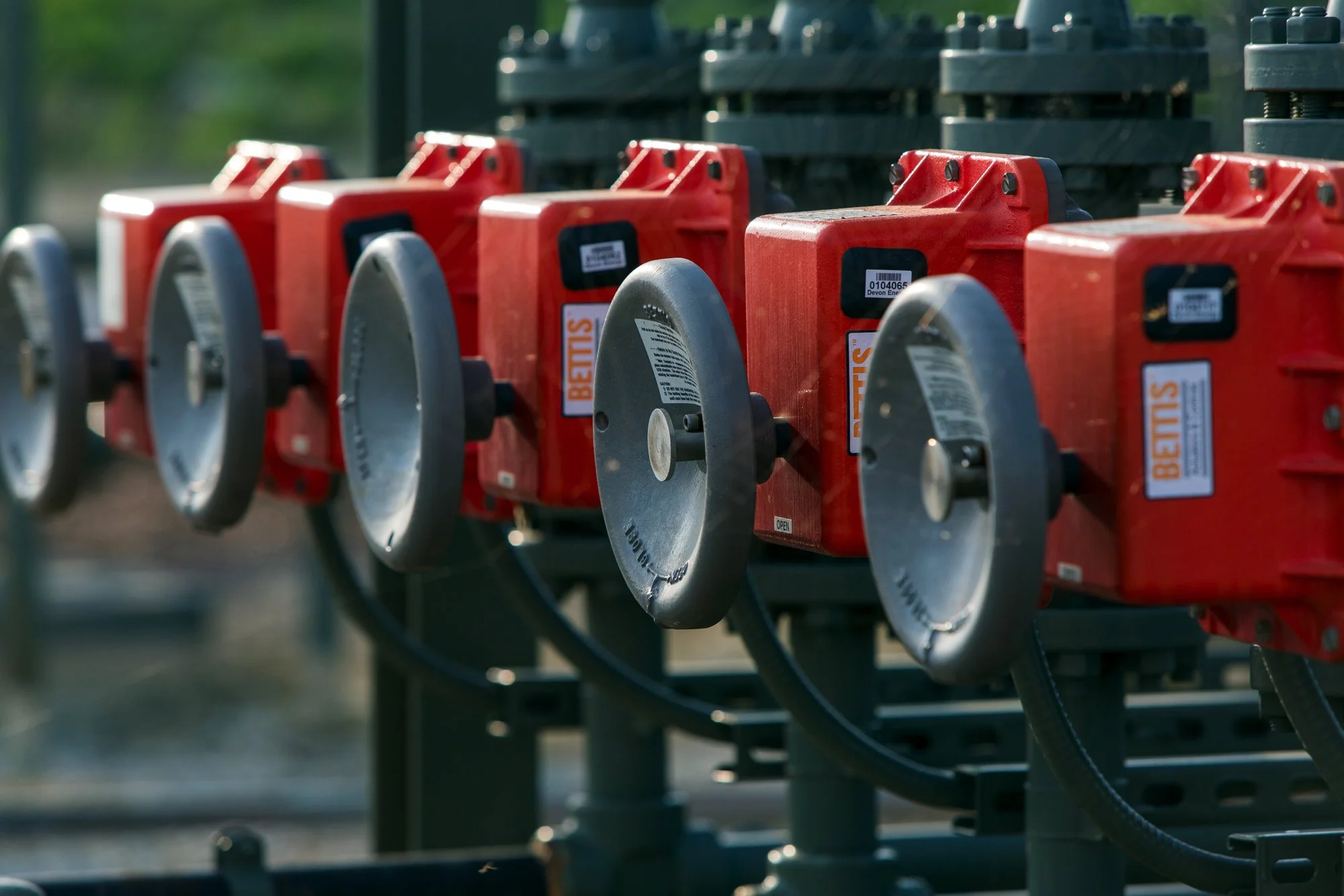 Close-up of multiple orange industrial control boxes with black dials and cables, labeled 'BEIJIS'.