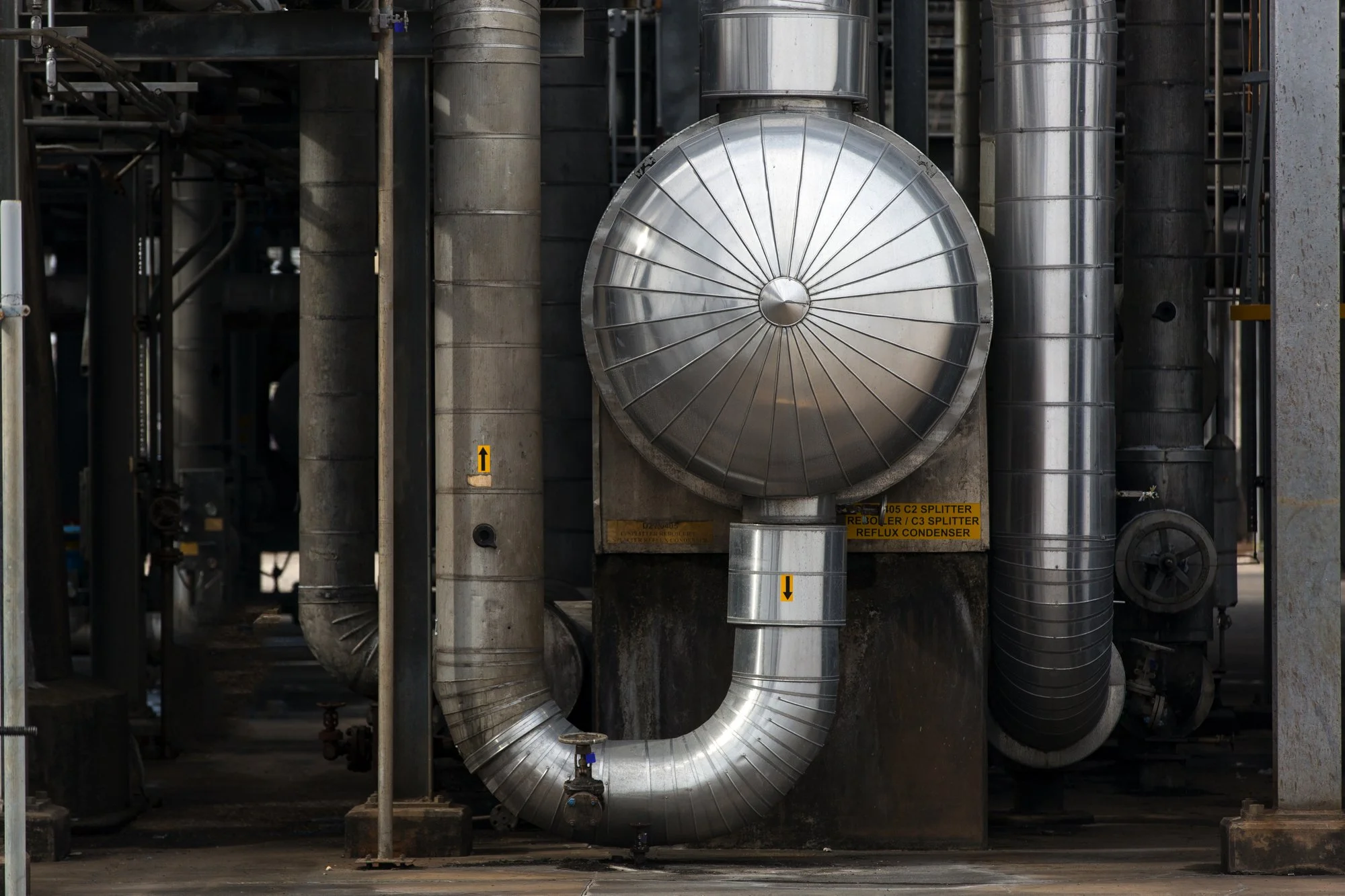 Industrial pipes and ductwork in a factory or plant setting.