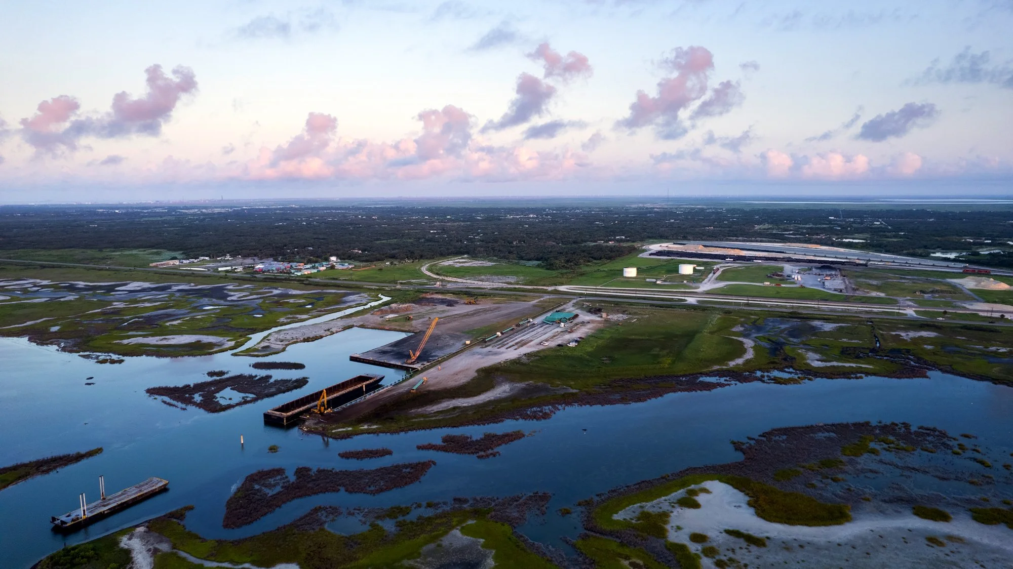 Aerial view of a water management area with waterways, construction, and surrounding greenery.