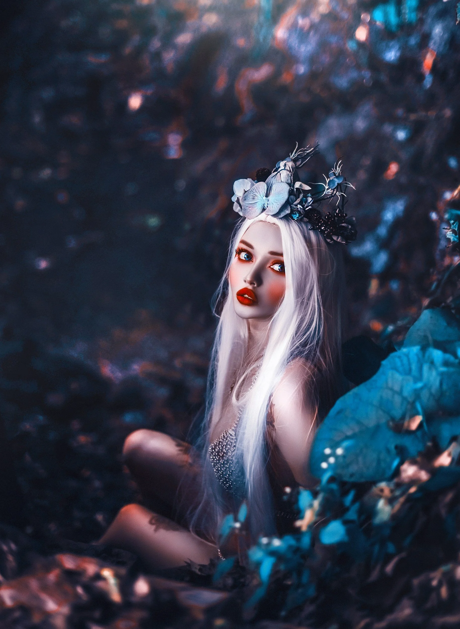 A woman with long platinum blonde hair, striking blue eyes, and red lipstick, wearing a crown of large blue and black flowers, sitting among vibrant foliage with blue and purple hues.
fantasy ghostwriting
fantasy novel
worldbuilding
epic fantasy
fant