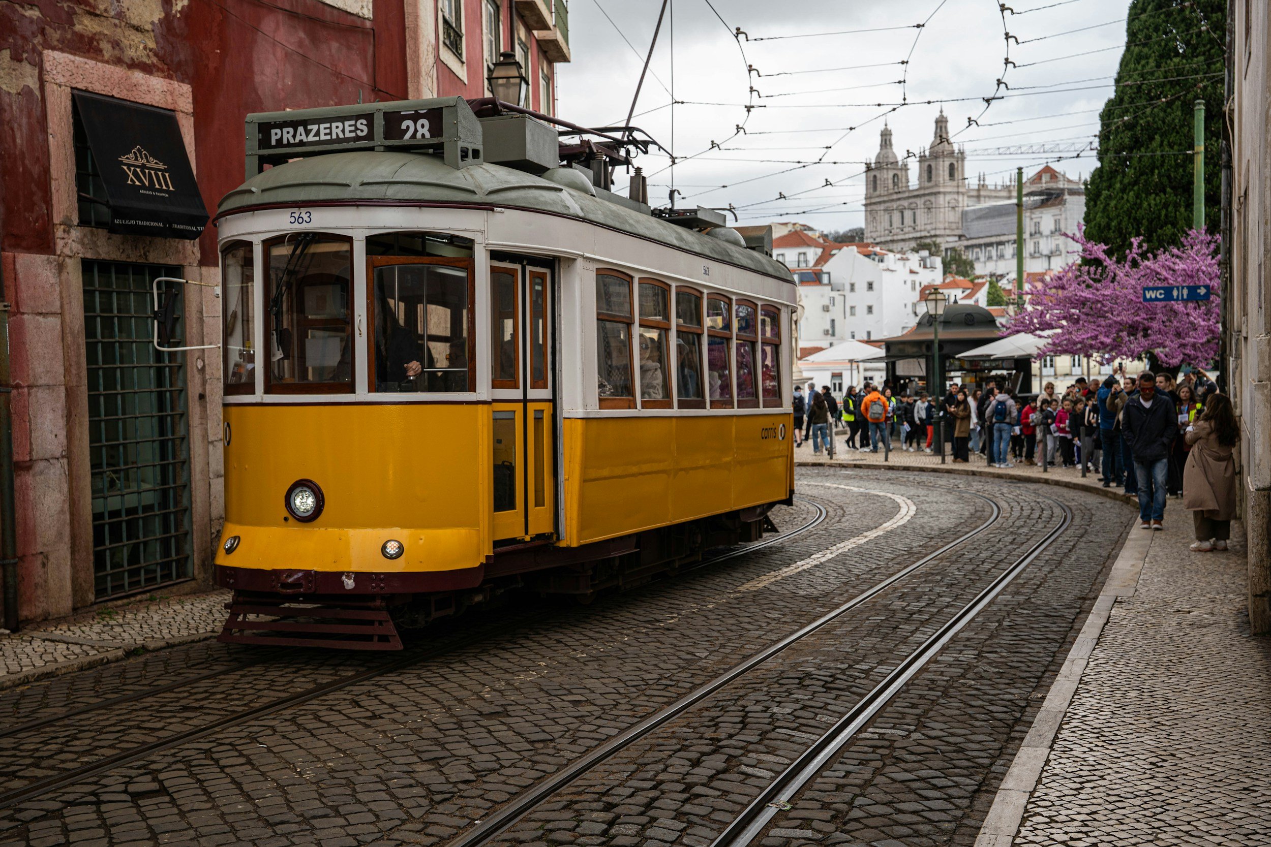 Lisbon tram 28 historic yellow tram narrow street
