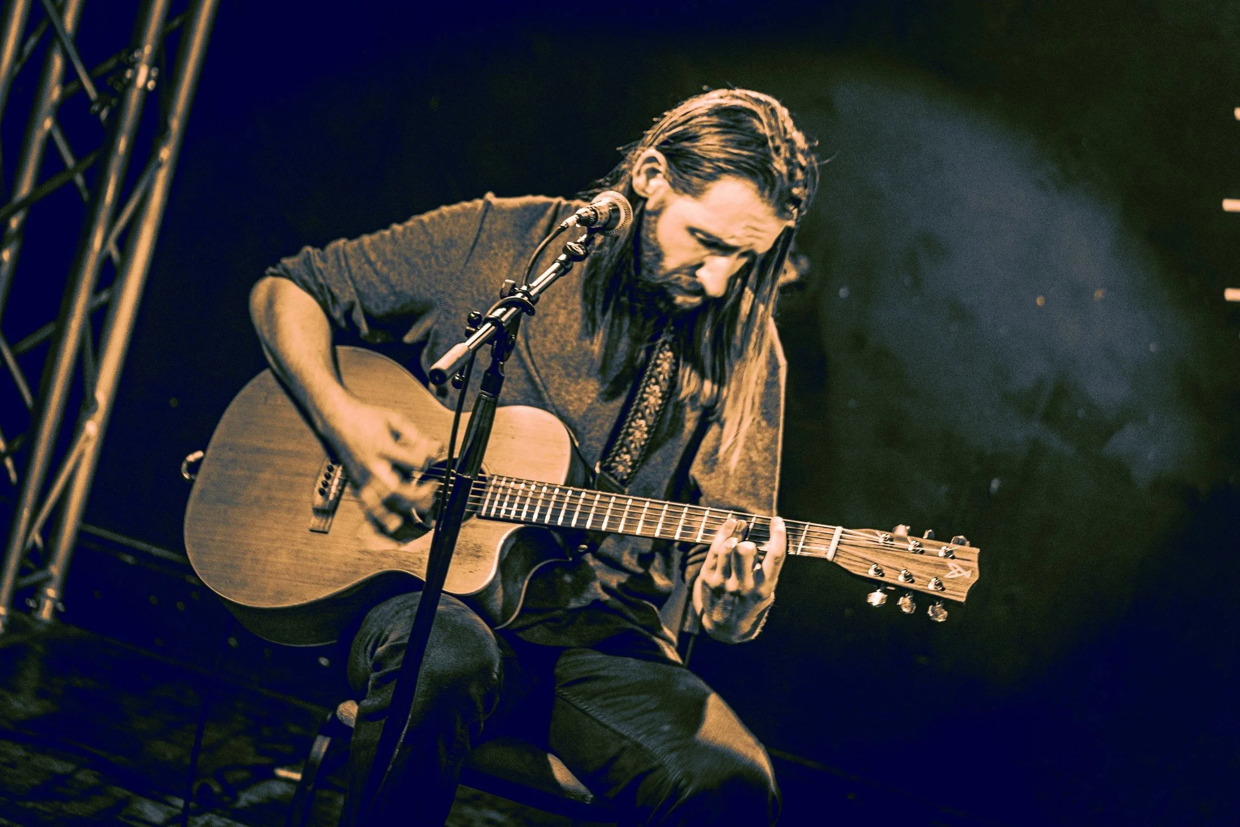 Lloyd Edwards playing acoustic guitar and singing on stage