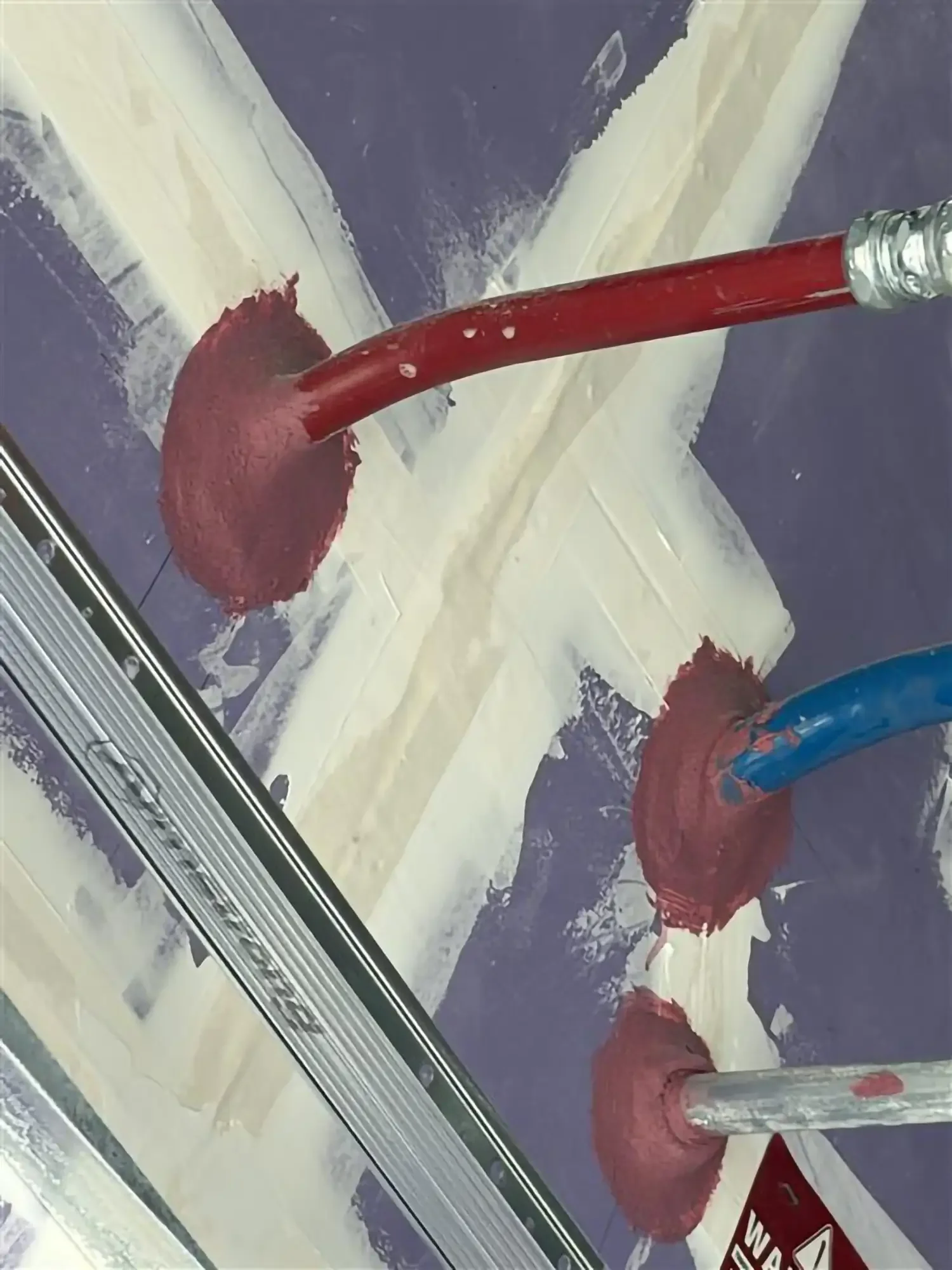 A person cleaning snow and ice off a glass window with a squeegee during winter weather.