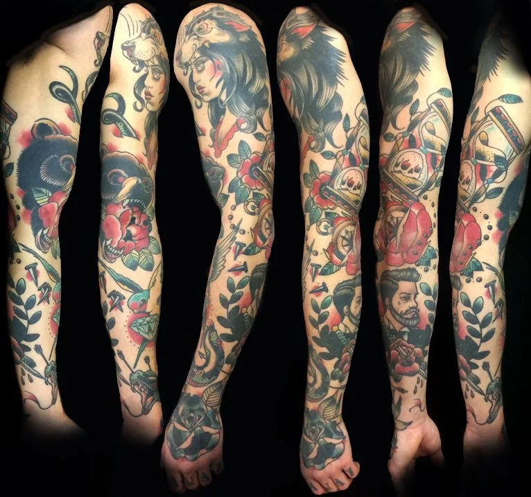 Full sleeve tattoo, featuring a lion, woman, skulls, roses, and traditional American tattoo designs with bold colors and black outlines.