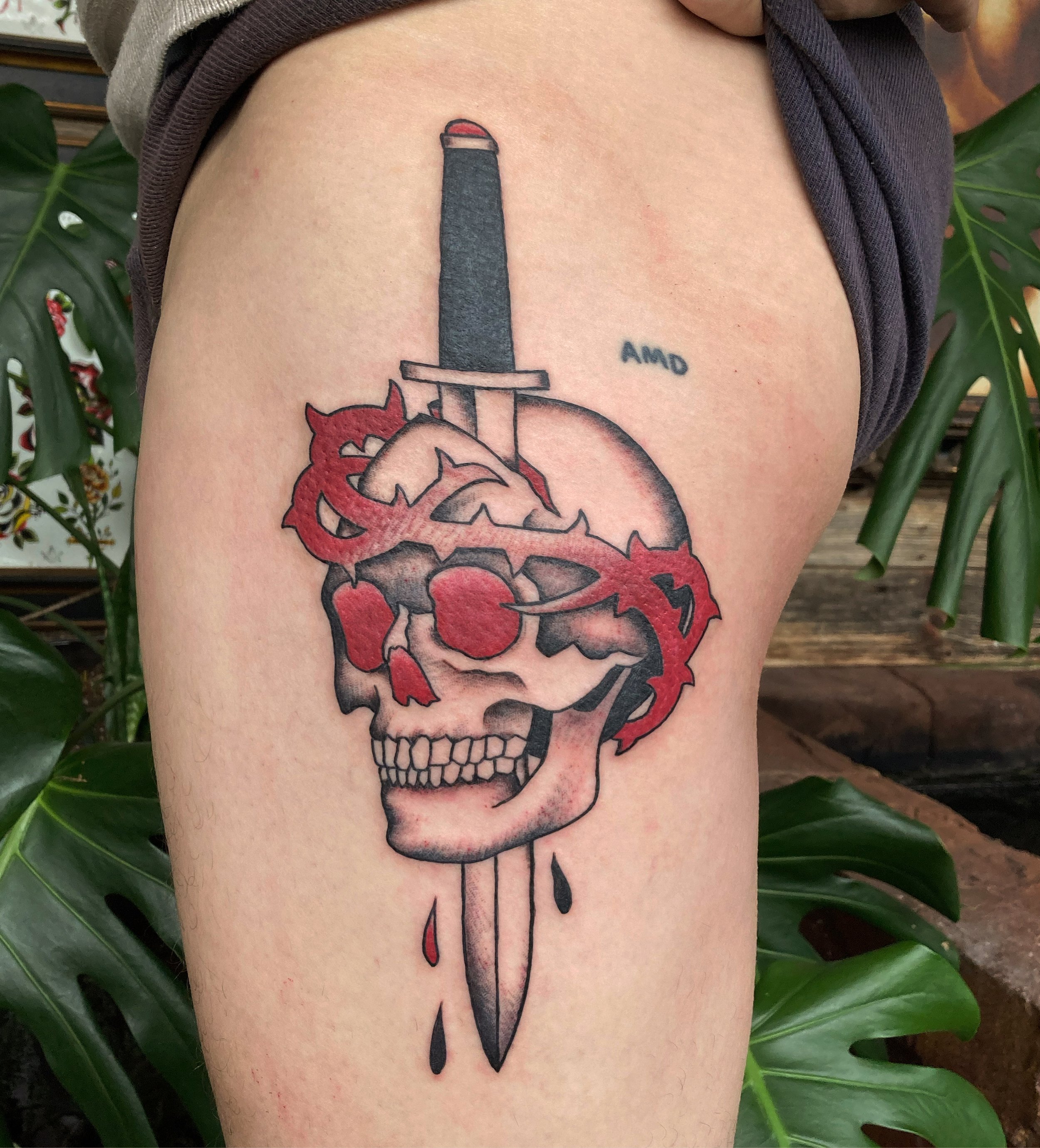 Tattoo of a skull pierced by a sword.