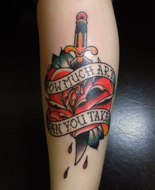 Tattoo of a sword piercing a heart with a banner saying 'How much art can you take' and drops below.