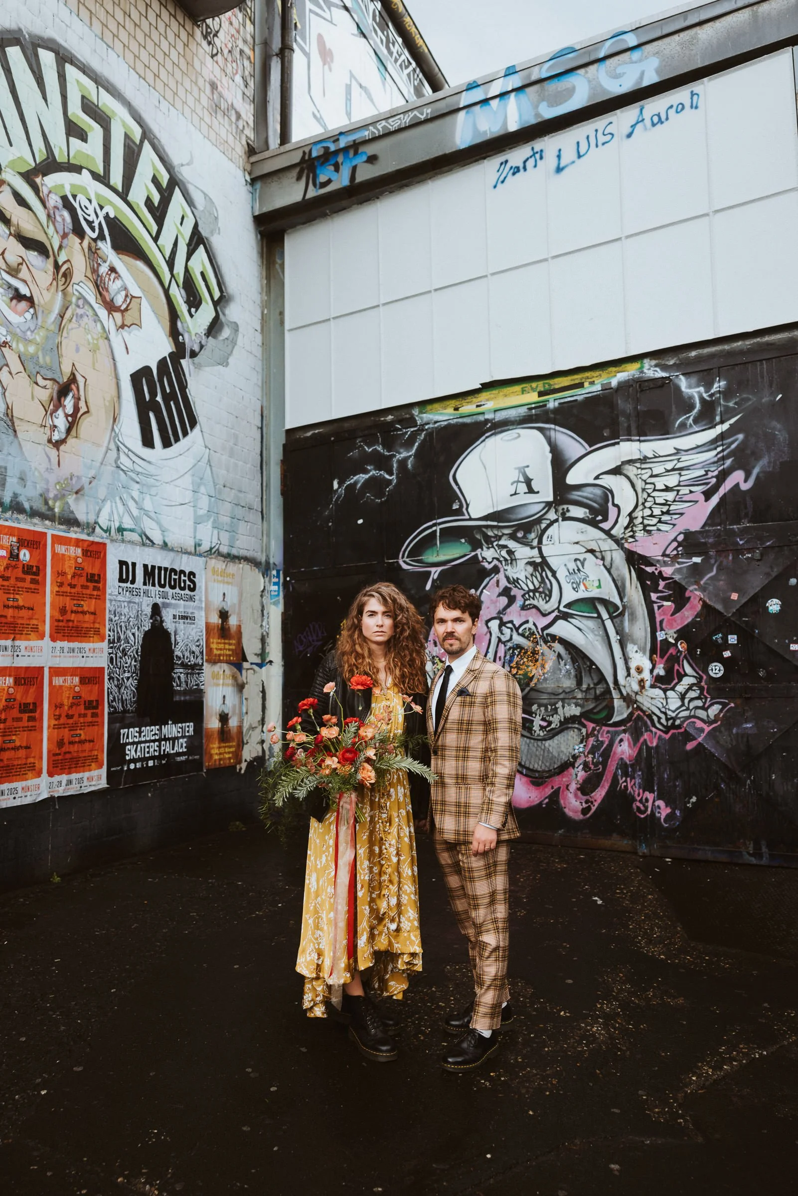 Alternatives Hochzeitspaar mit großem Blumenstrauß vor Graffiti im Skaters Palace Münster