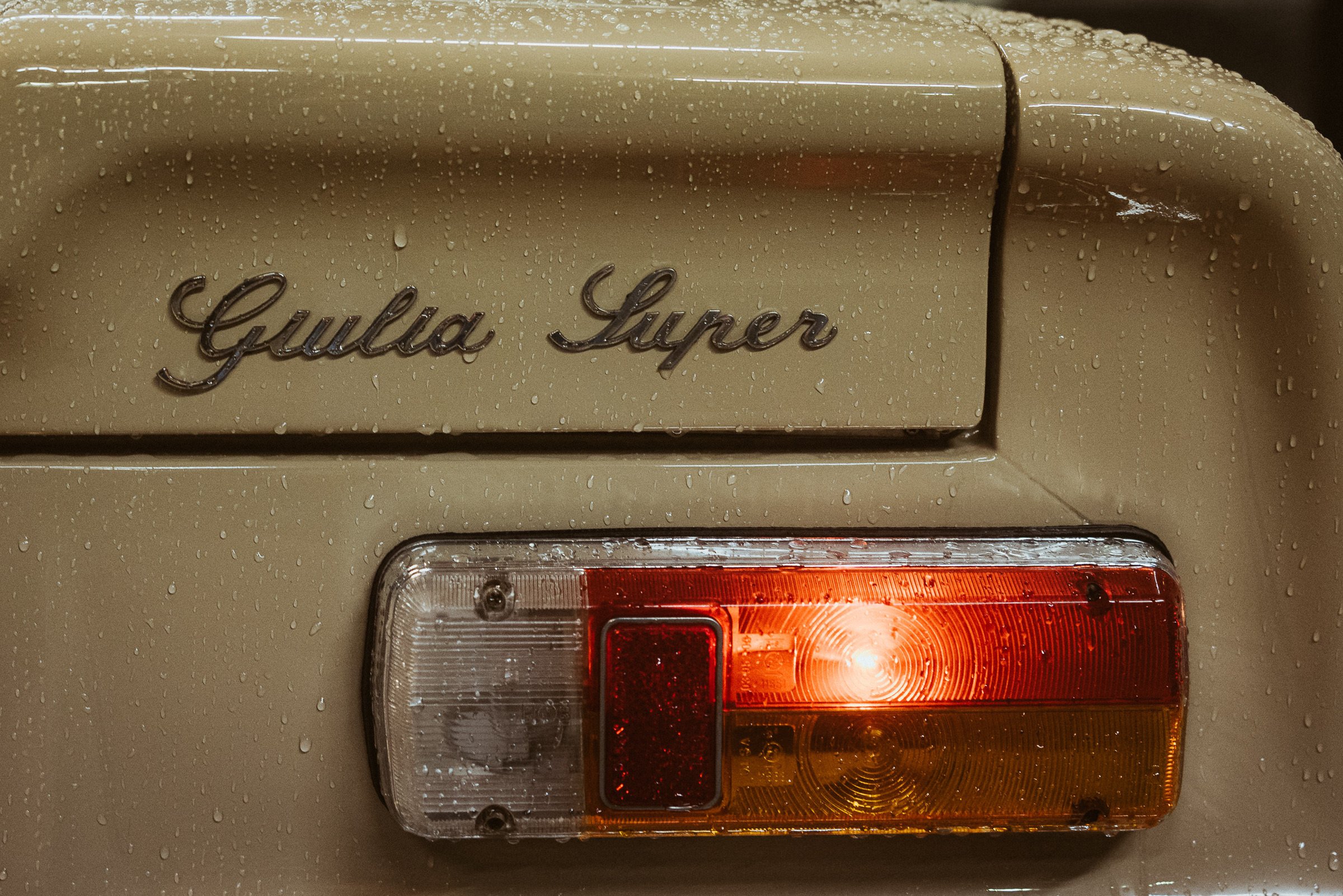 Nahaufnahme des Heckteils eines Autos, das den Markennamen 'Gullia Super' aufweist, mit Wassertröpfchen auf der Oberfläche.