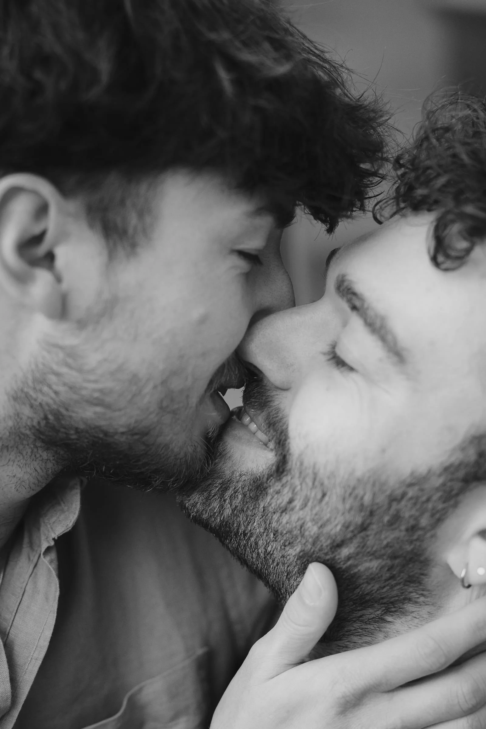 Zwei Männer küssen sich liebevoll mit geschlossenen Augen, Nahaufnahme ihrer Gesichter, Schwarz-Weiß-Fotografie