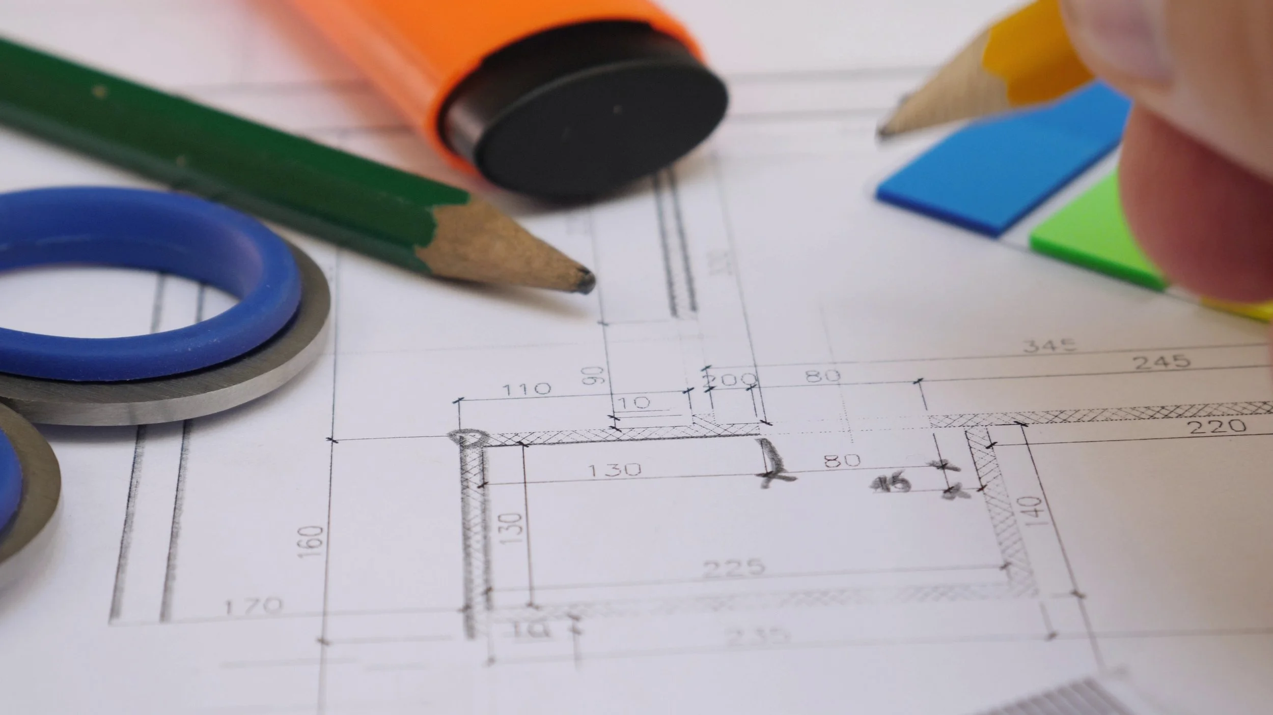 A spec sheet with measurements on and a pencil and highlighter