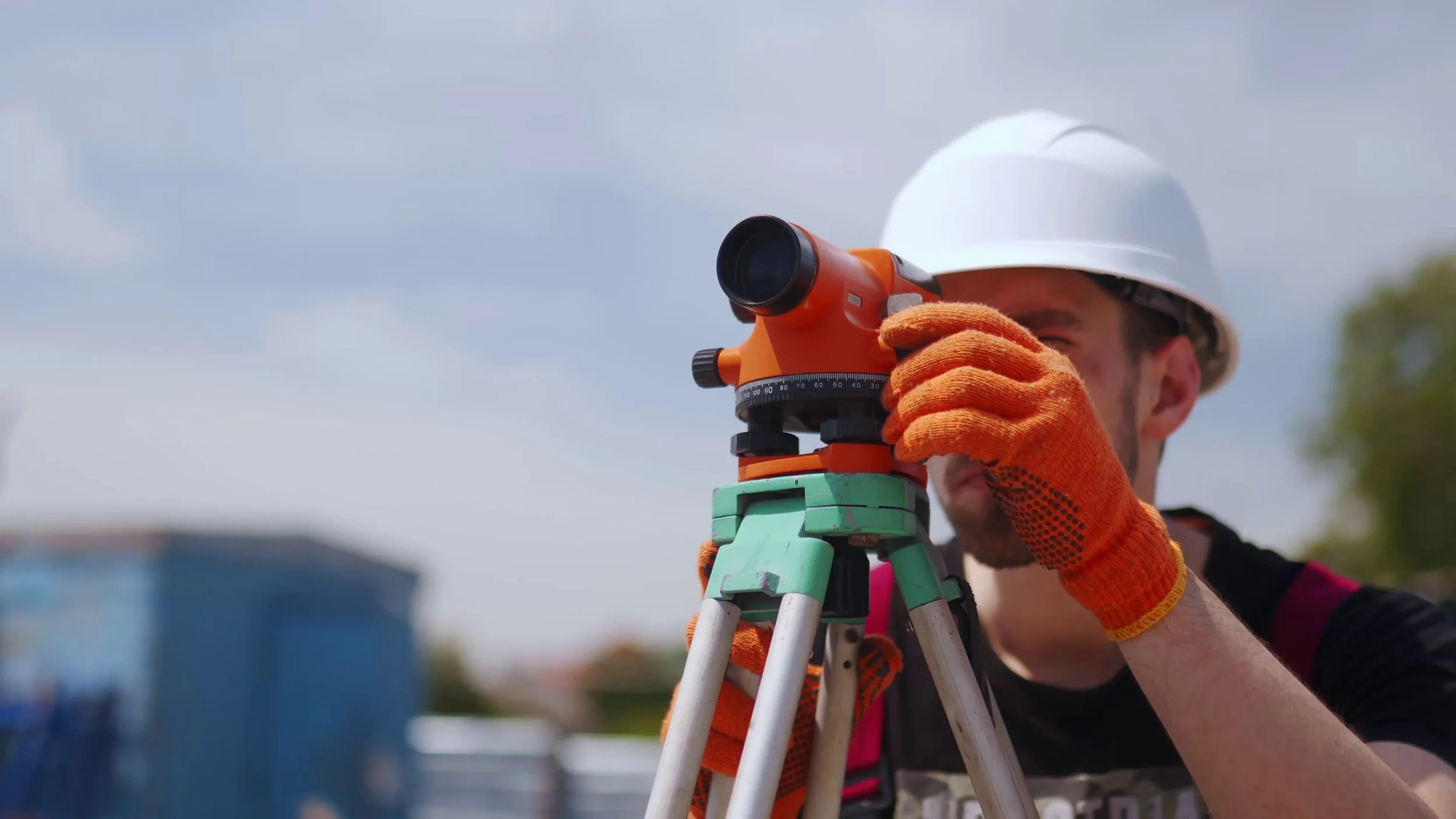 construction worker uses optical level on construction site