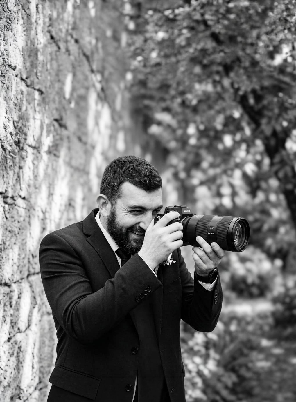 UK Wedding Photographer, Alex Gell, holding a camera whilst photographing