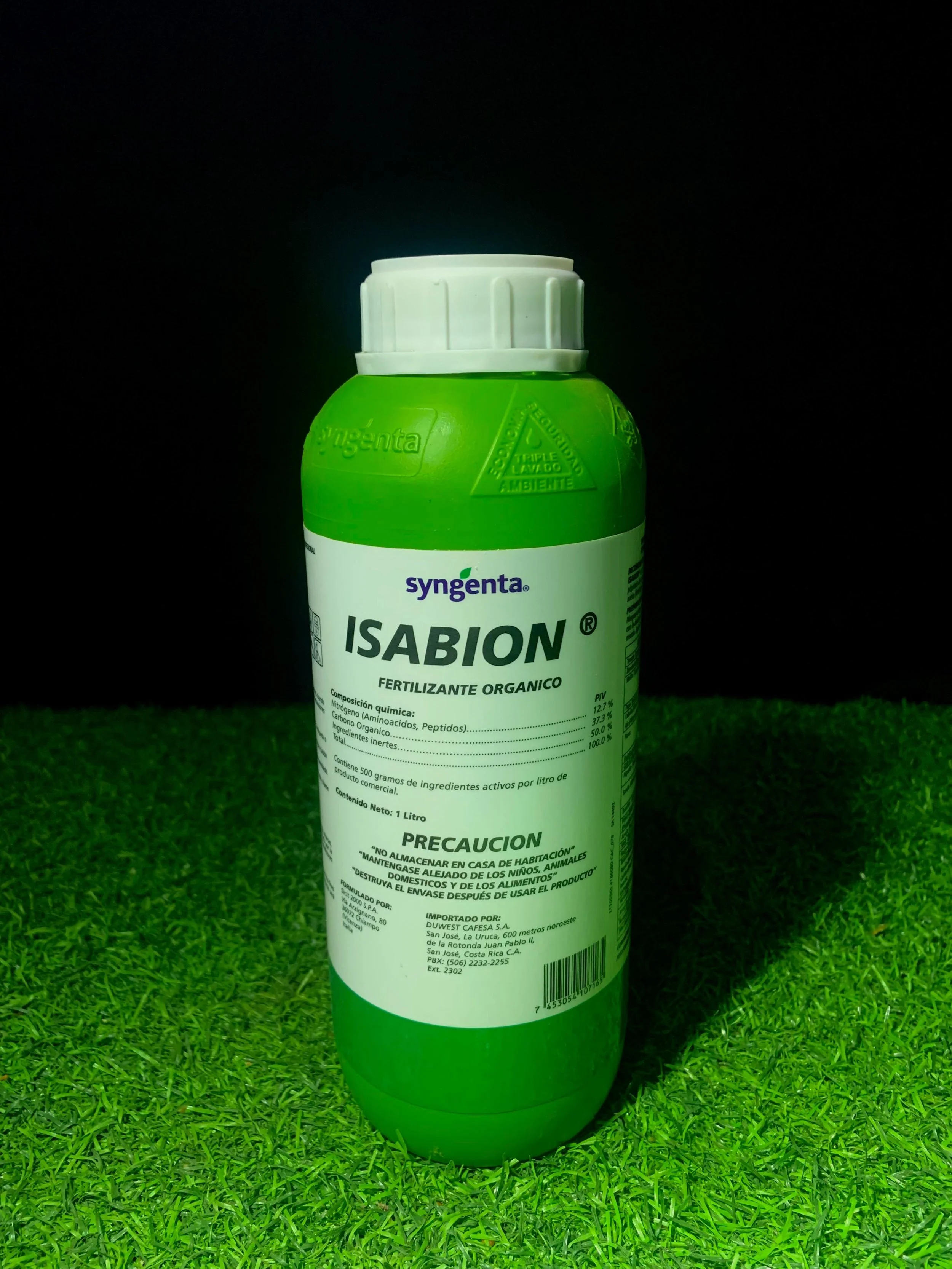 Envase de fertilizante orgánico ISABION de Syngenta en color verde con etiqueta blanca, colocado sobre césped artificial, con fondo negro.
