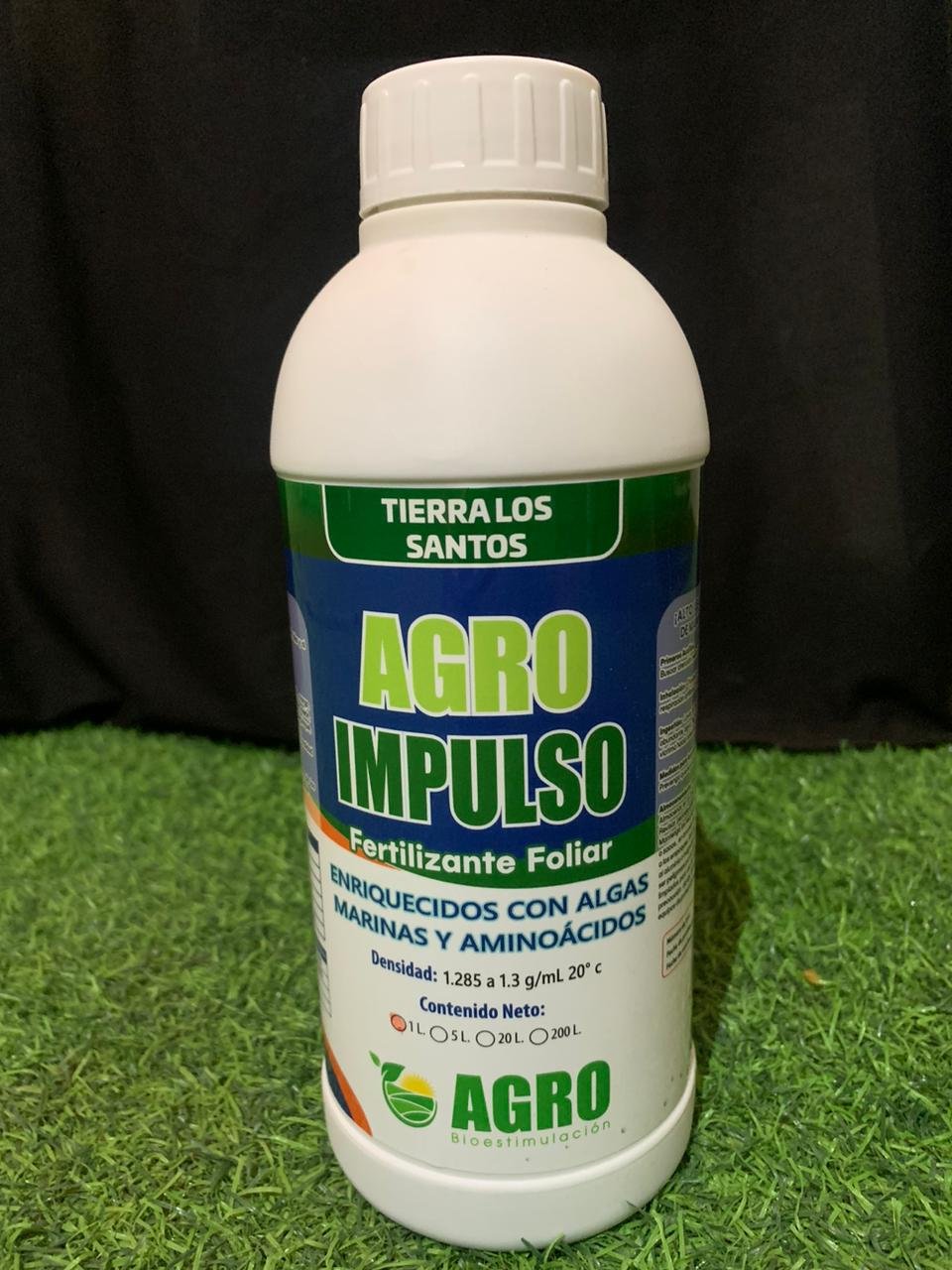 Botella de fertilizante foliar llamado AGRO IMPULSO, con las palabras 'Tierra Los Santos' en la parte superior. Incluye descripción de su uso y características técnicas en español.