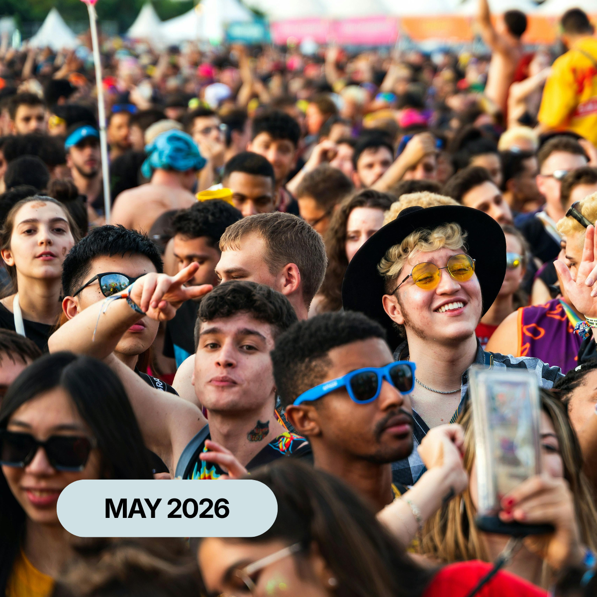 A large crowd smiling and celebrating at an outdoor festival
