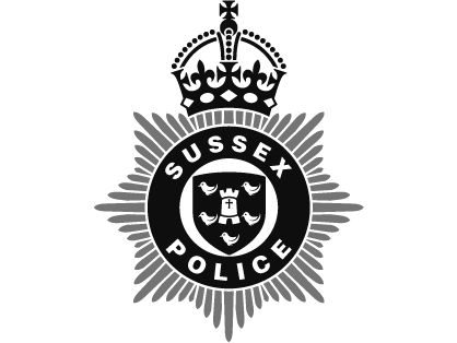 Sussex Police badge with crown and starburst design.