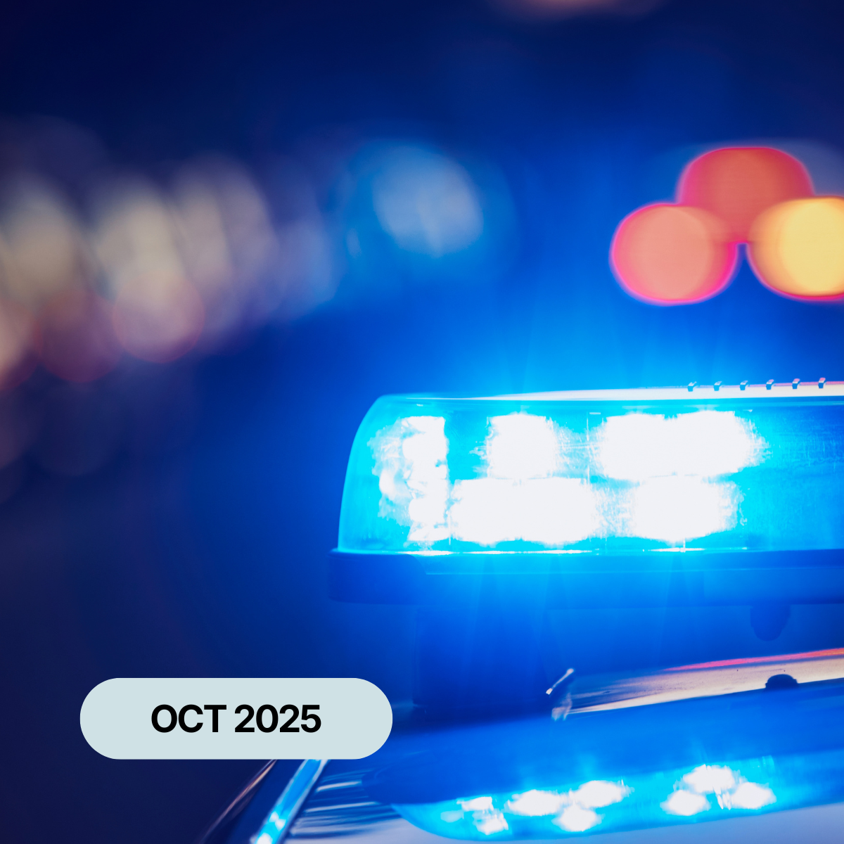 The blue lights of a police car flashing in the night-time