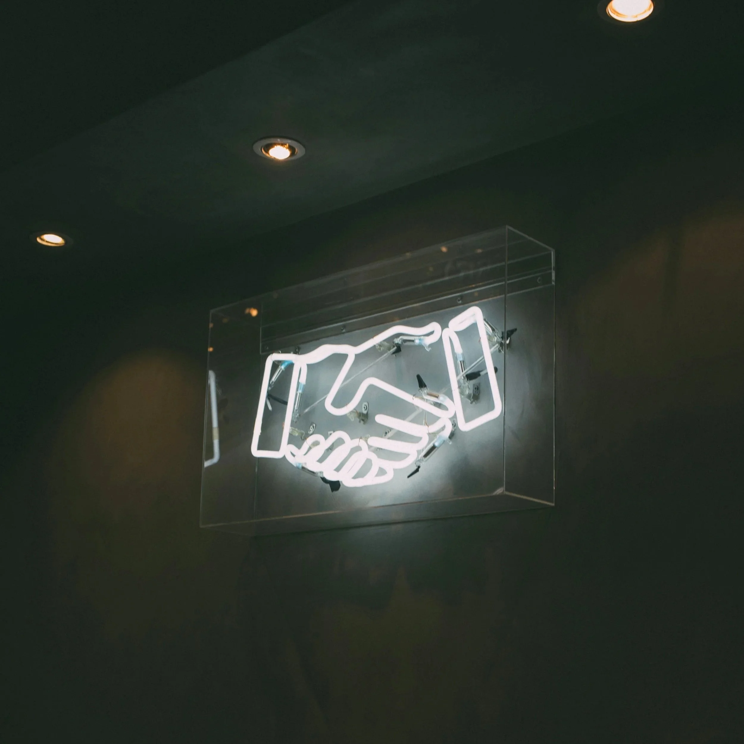 White neon light of two hands shaking