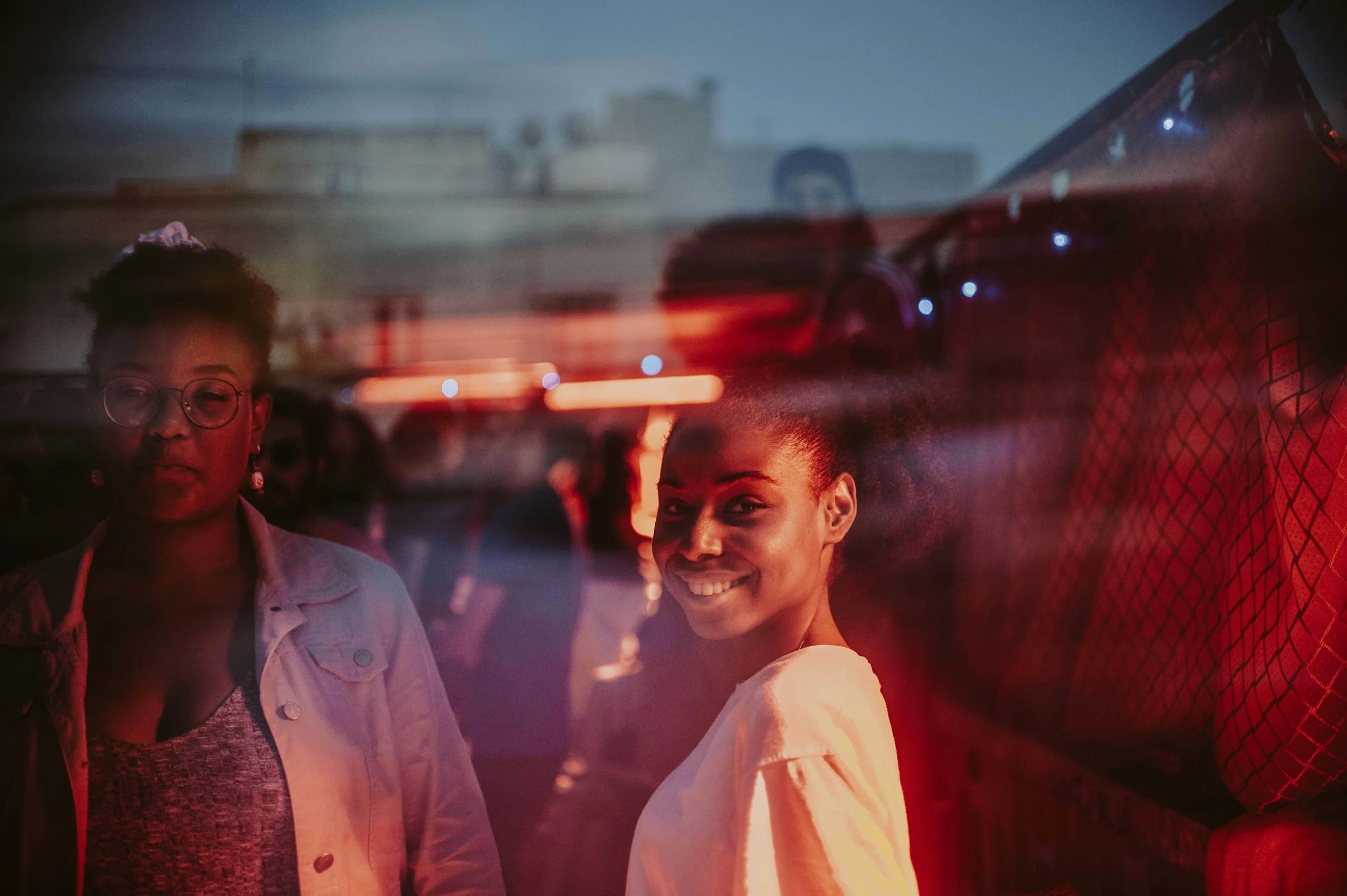 Two people enjoying a night out in a warmly lit social setting.