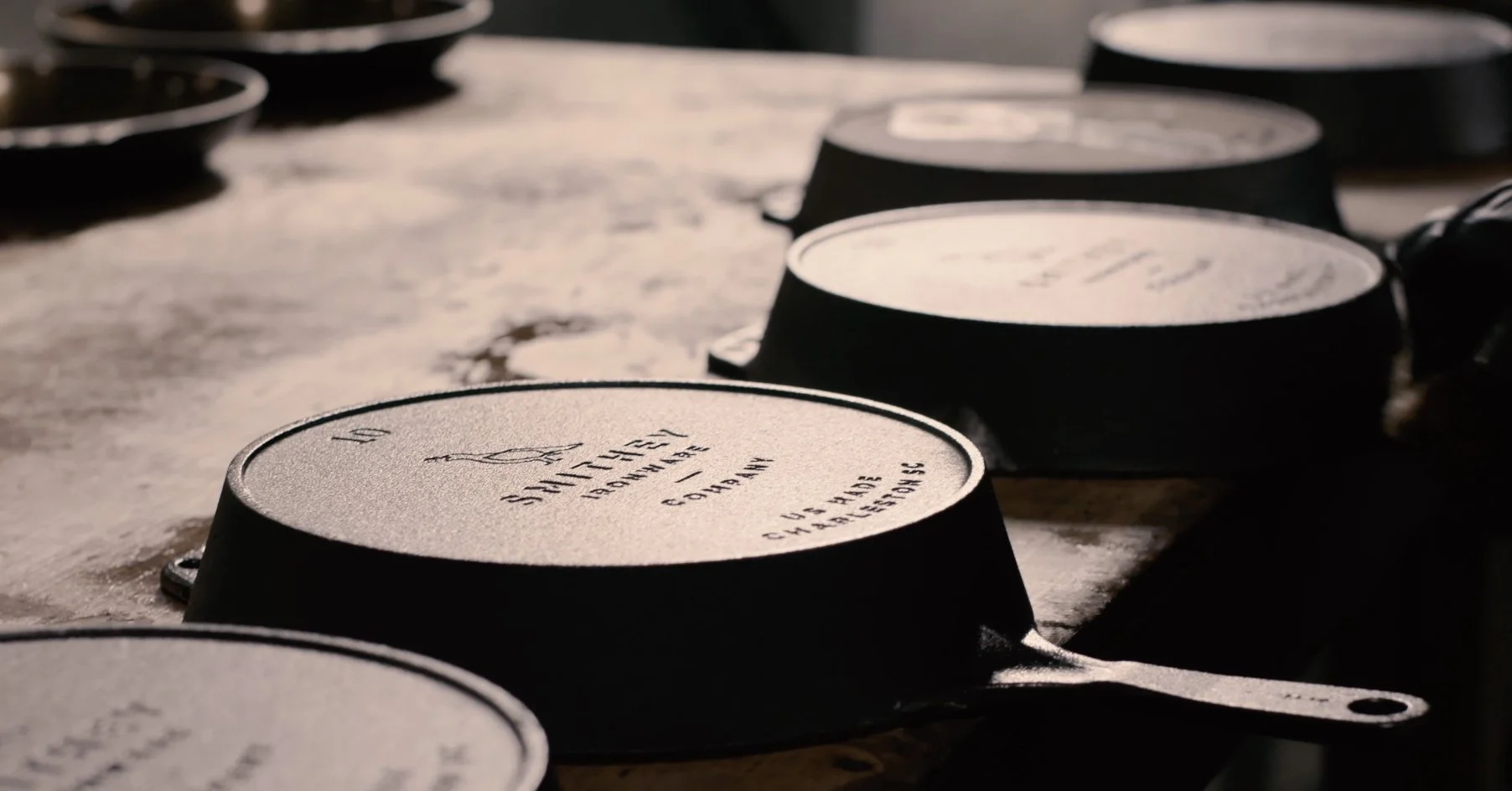 Close-up of engraved coffee cups stacked upside down on a rustic surface.