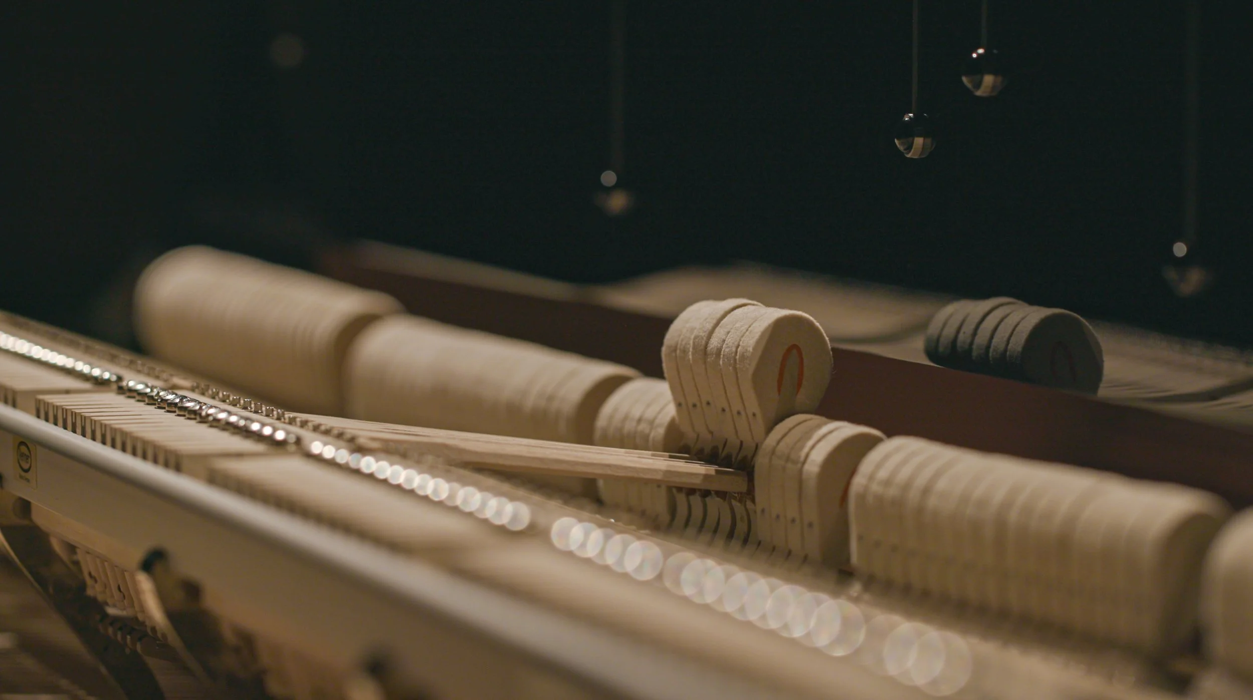Close-up of the interior of an upright piano, showing the hammers and strings.