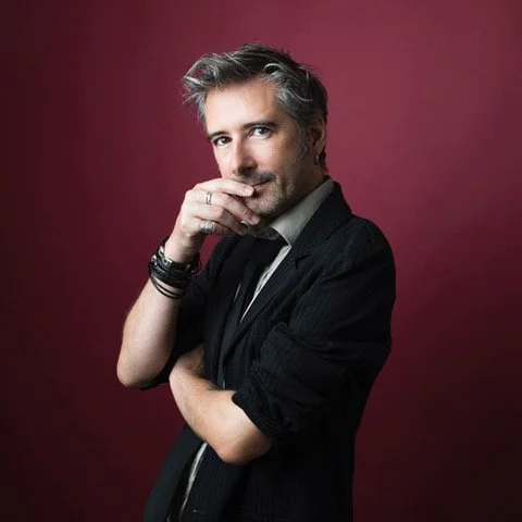 Portrait Gilles Marchand sur fond rouge.