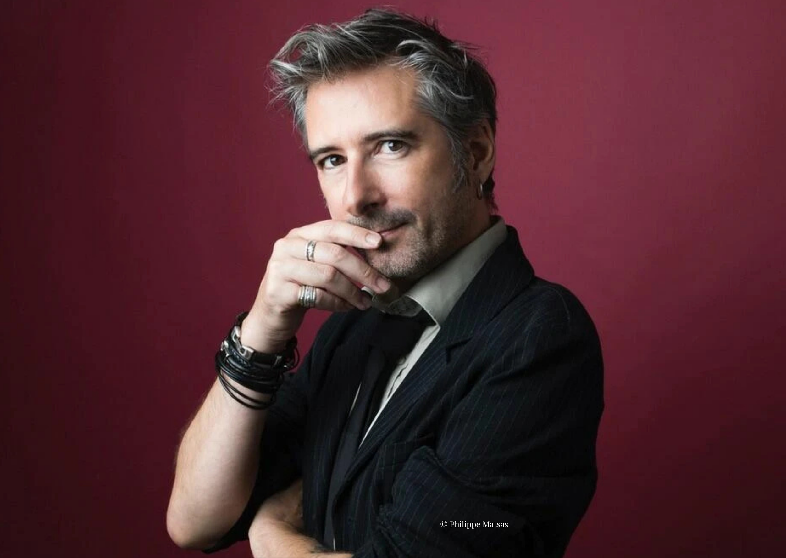 Portrait Gilles Marchand sur fond rouge.