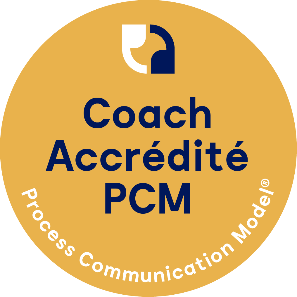 Badge rond doré avec texte bleu indiquant 'Coach Accrédité PCM' et message en blanc 'Process Communication Model' en courbe en bas.