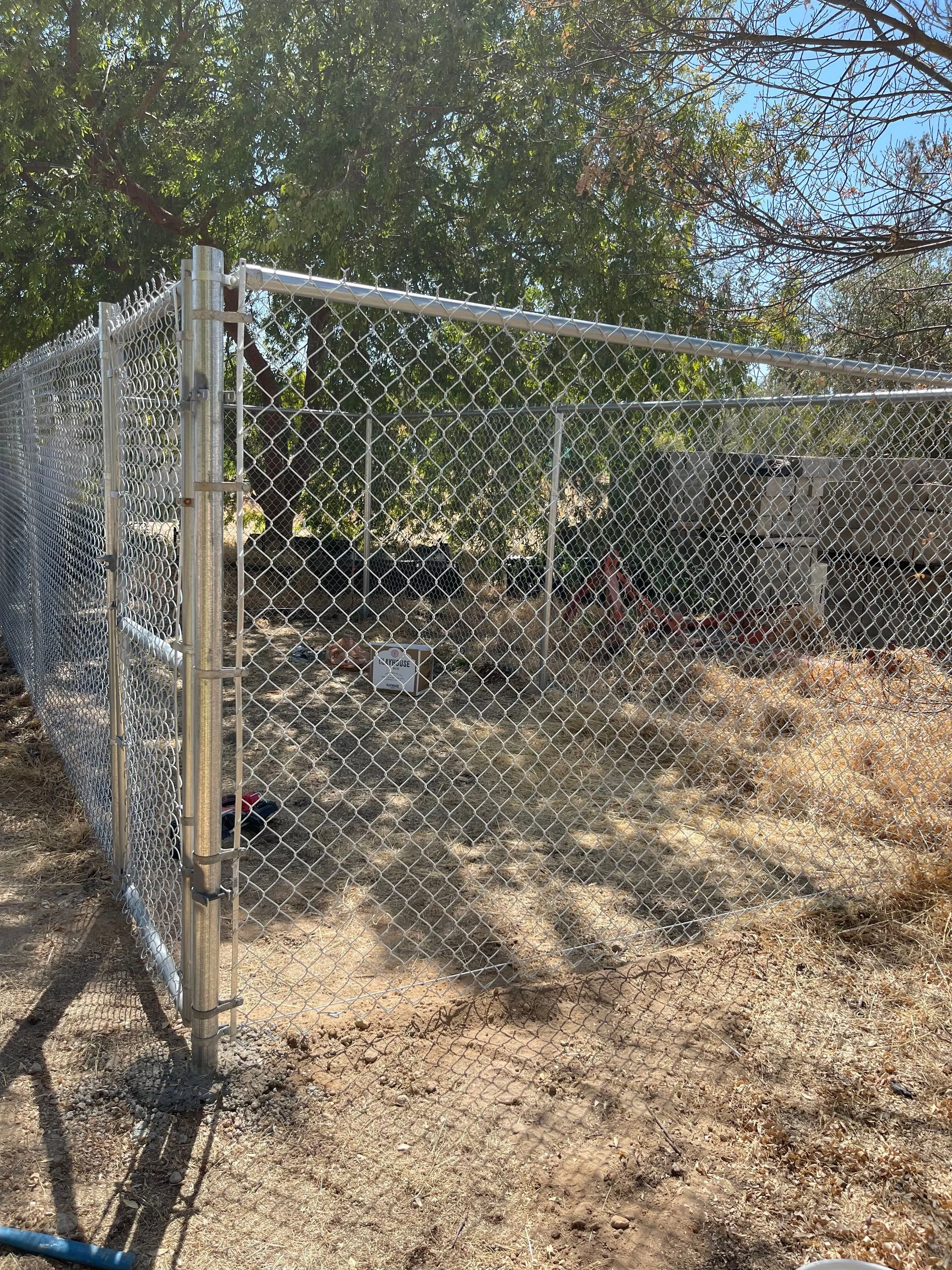 Residential chain link fence installation enclosing backyard property area