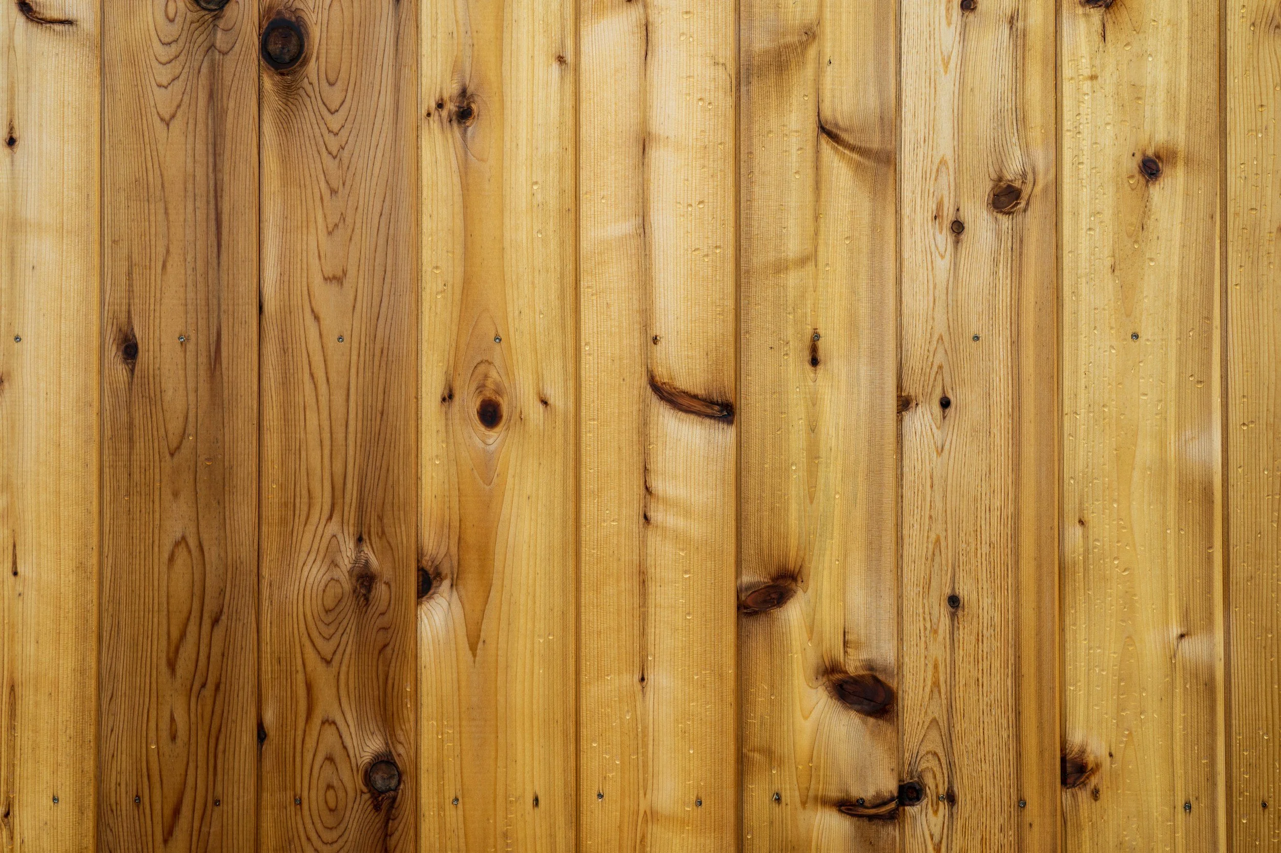 Close-up of a wooden fence made of vertically aligned planks with visible grain and knots.