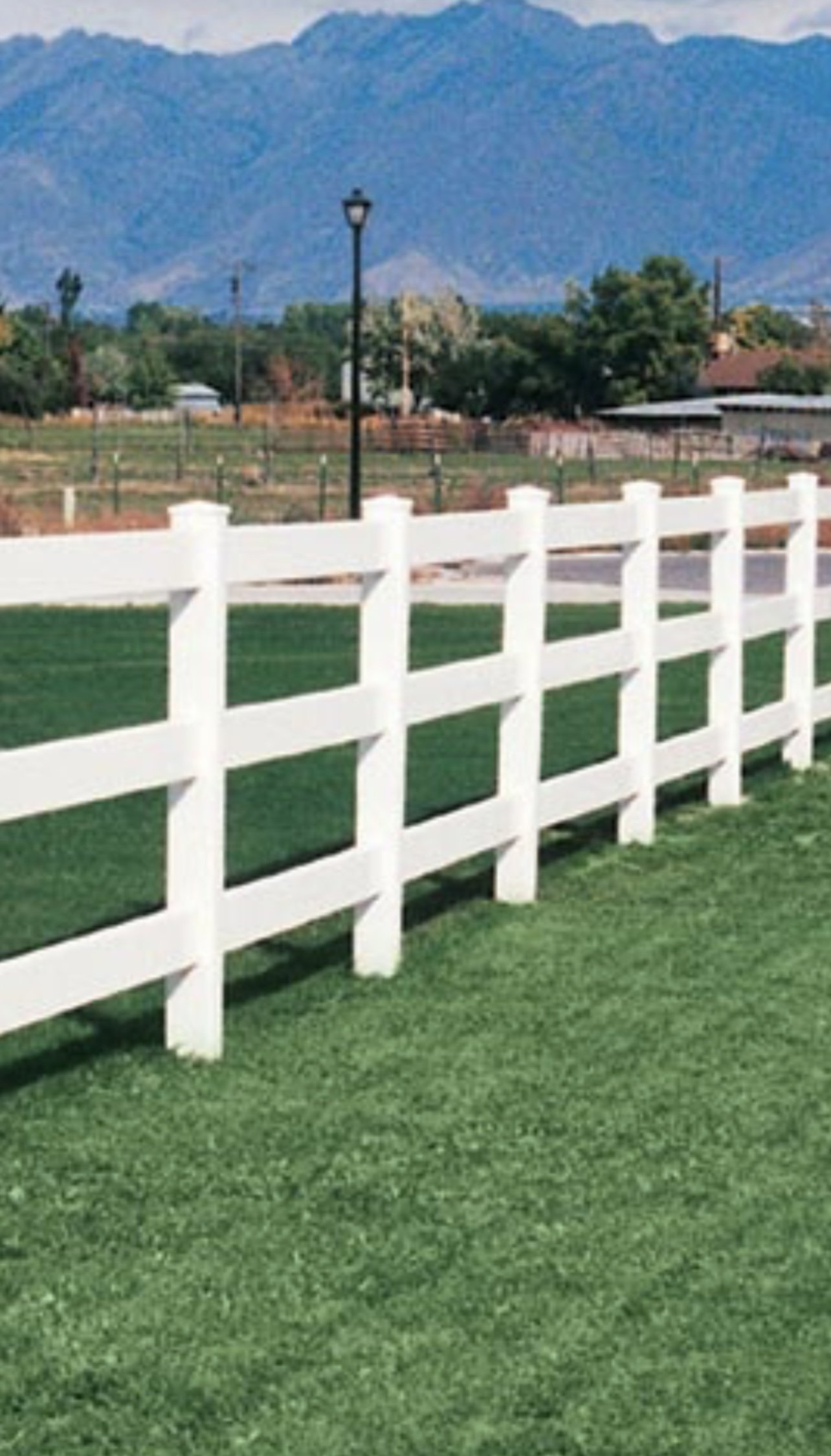 White vinyl ranch style fence installed for residential property boundary