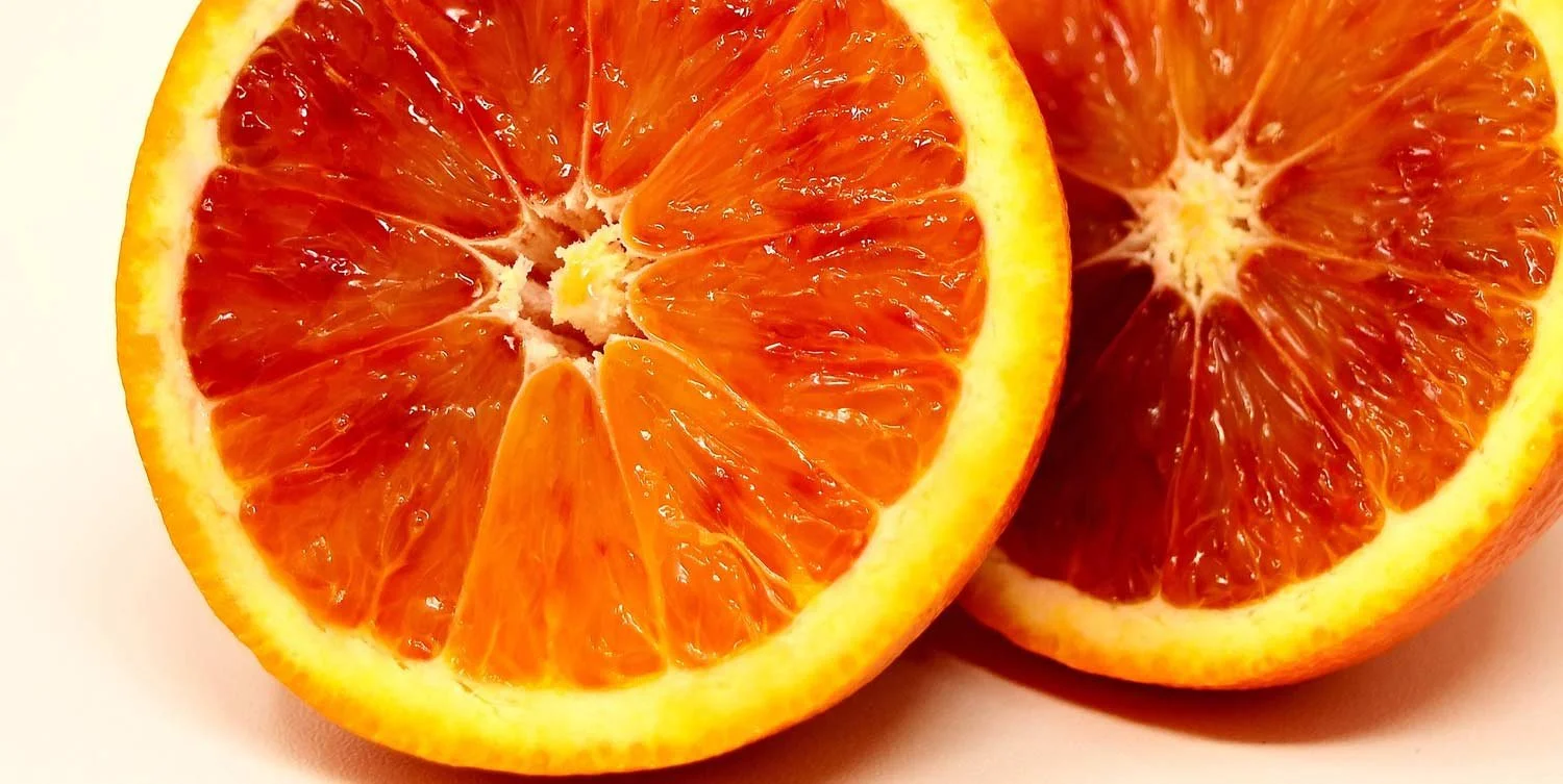 Close-up of two halved oranges showing juicy interior