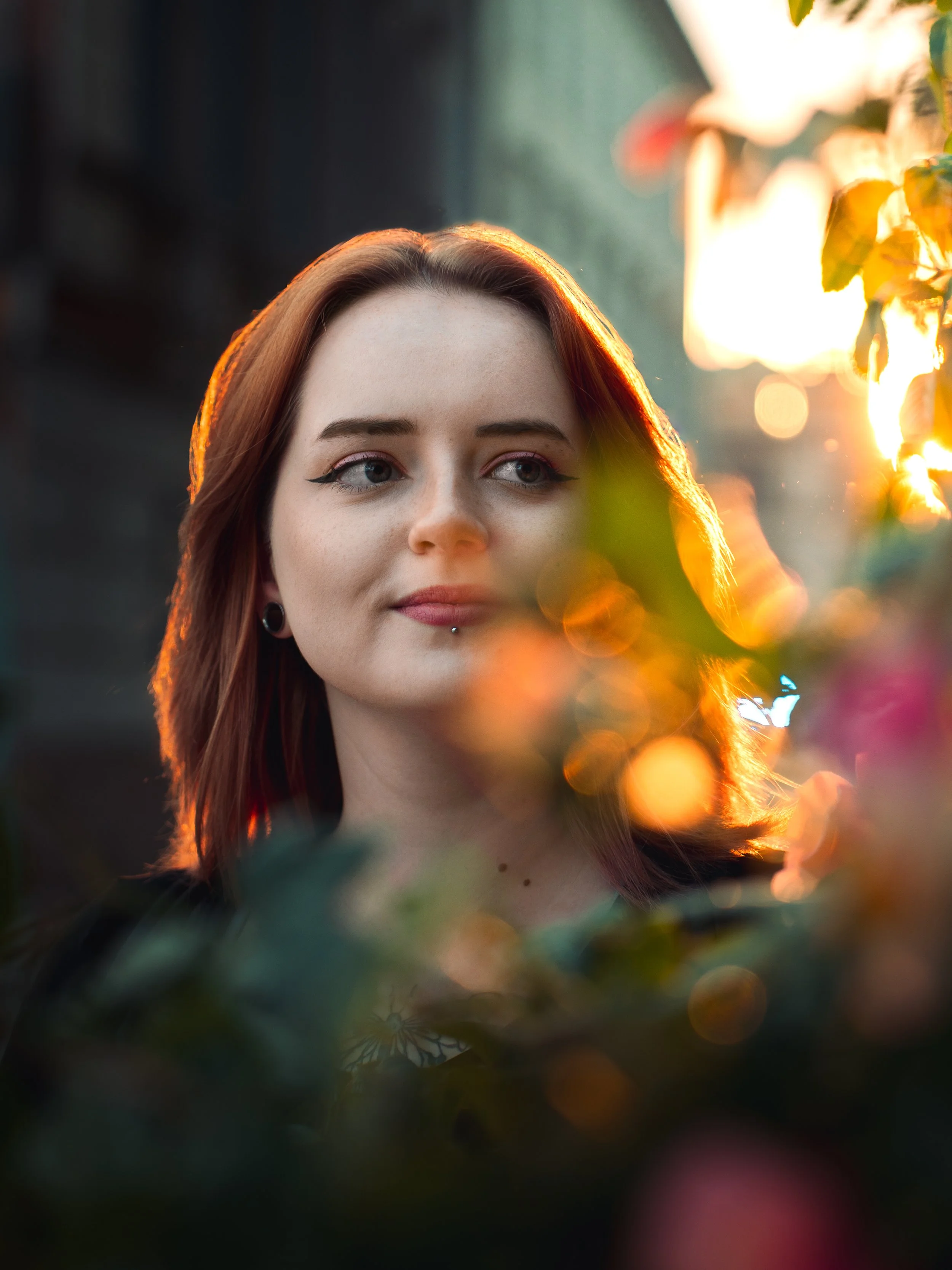 Portret rudowłosej kobiety w ciepłym świetle zachodzącego słońca