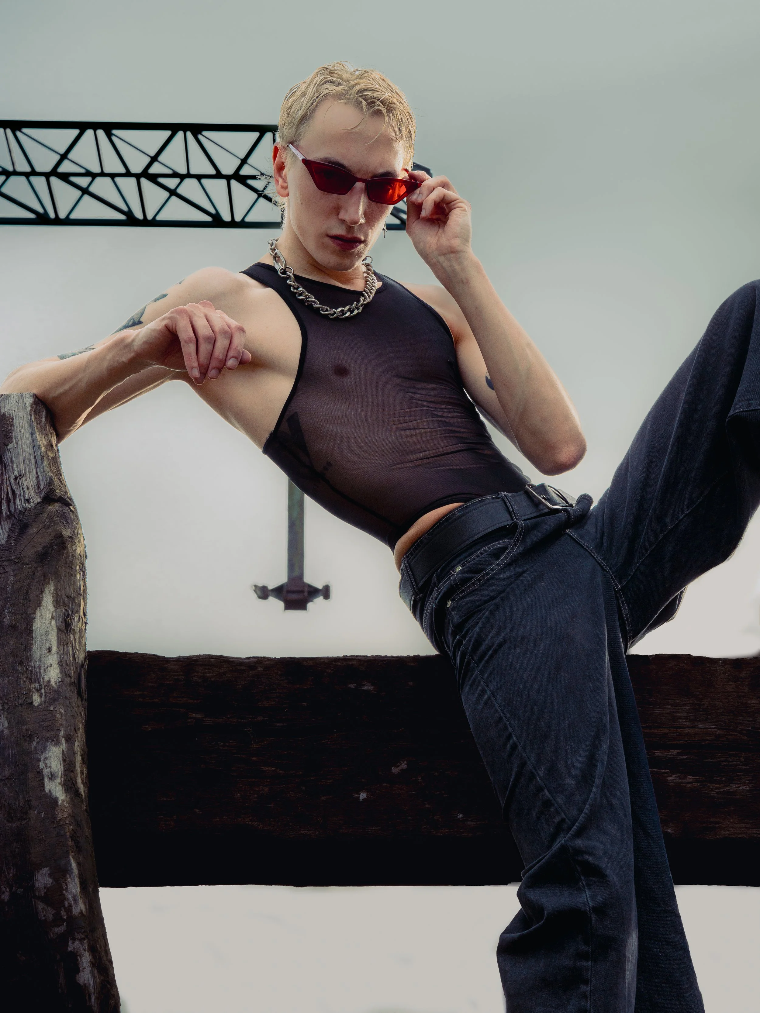 Portret mężczyzny w okularach przeciwsłonecznych i czarnej stylizacji