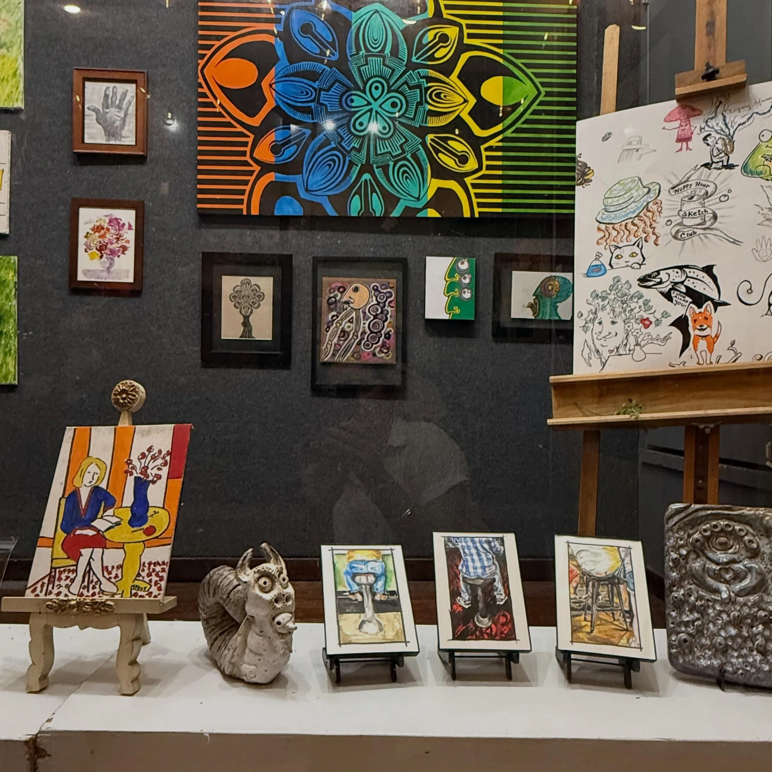 The Art of Showing Up

Happy Hour Sketch Club still gathers every Wednesday.
Artists of every experience level continue to pull up a chair, open a sketchbook, share ideas, and spend an evening making art together.

This beautiful window exhibition @t