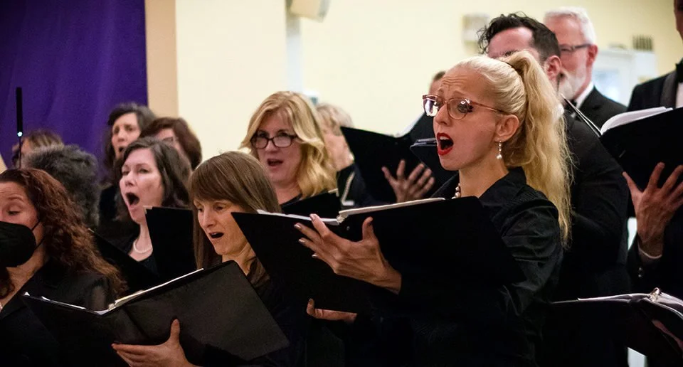 A group of Richmond Choral Society singers performing in concert.