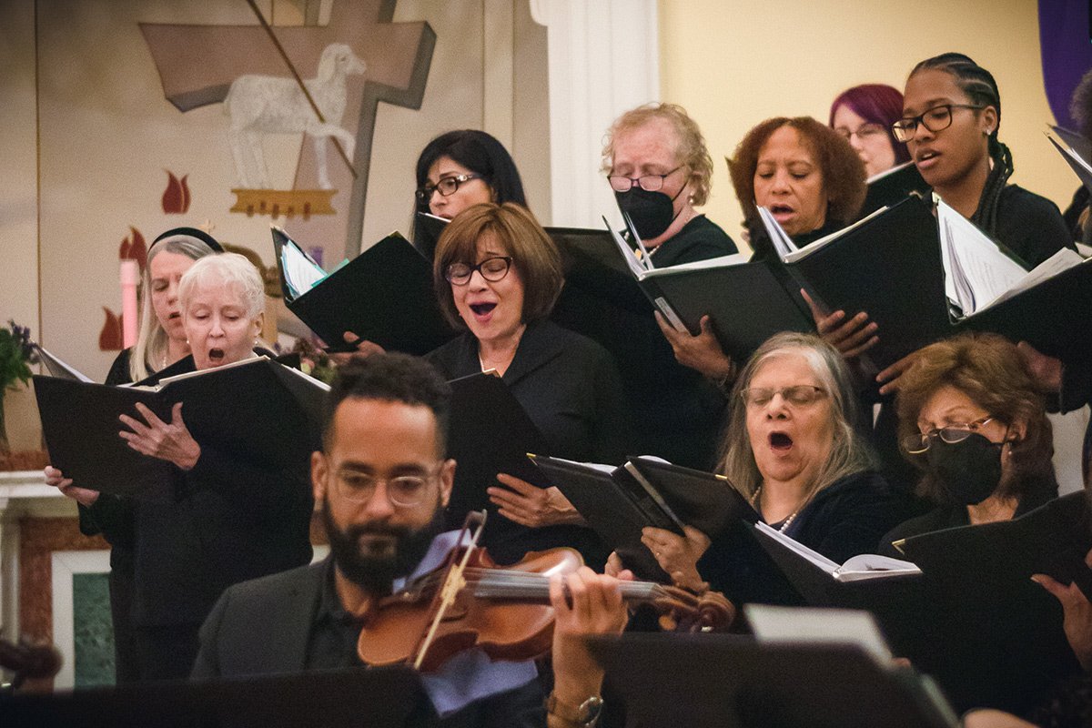 Members smiling while singing during a Richmond Choral Society performance