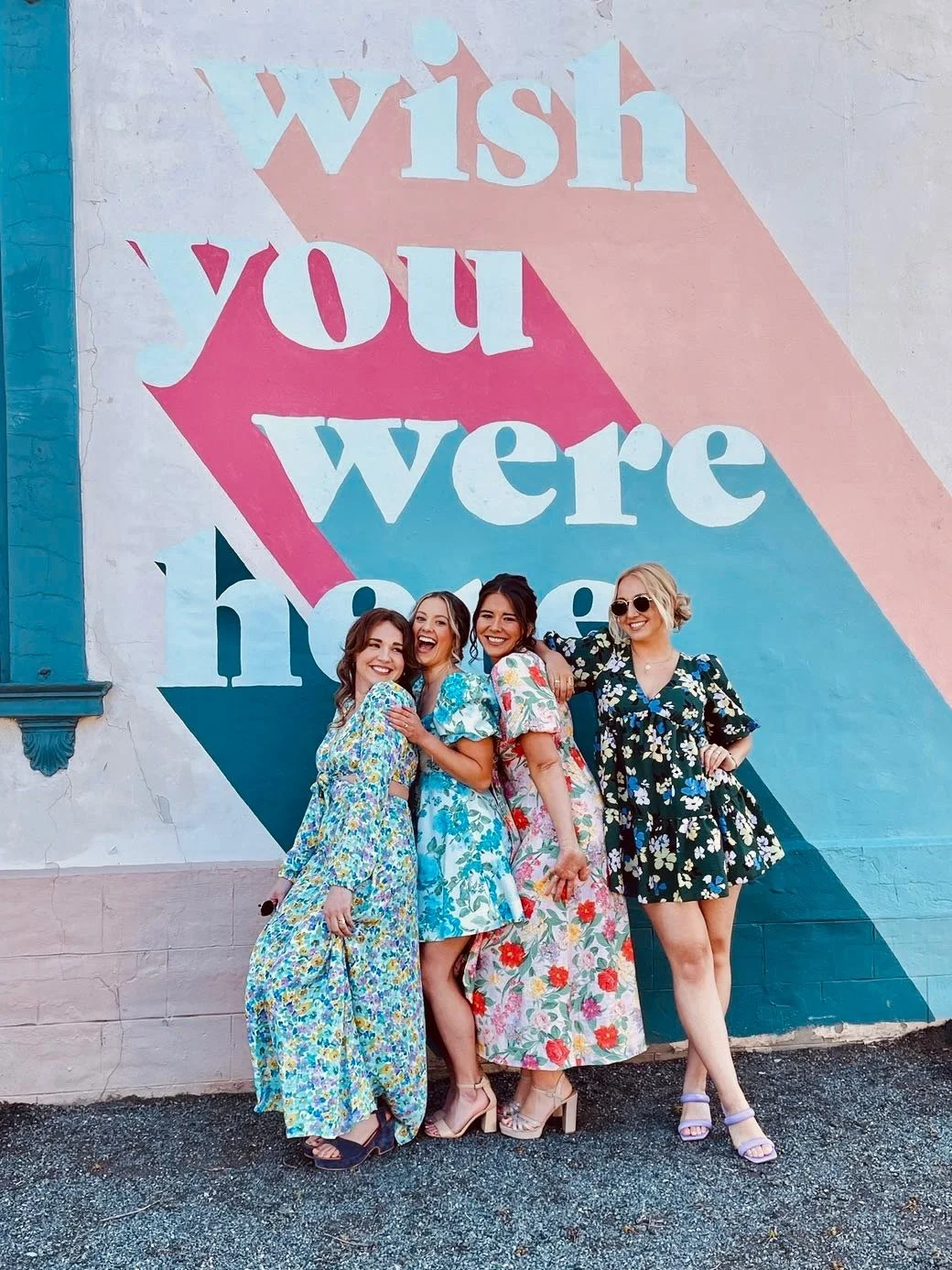 A group of women in fun, funky, floral dresses, ready for a special event in Hamilton, ON. Hair and makeup done by Freebird Beauty Co.