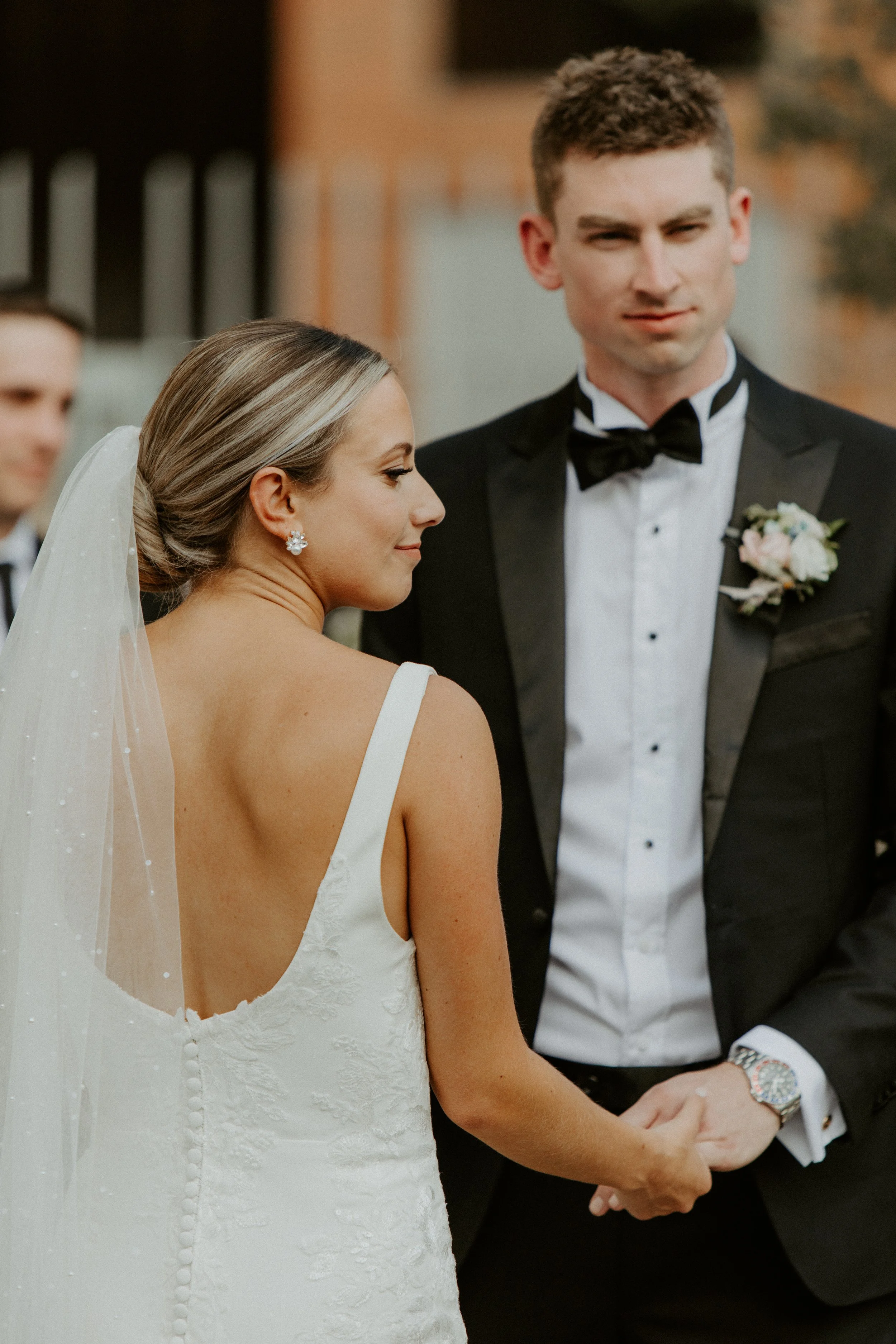 Bride and groom holding hands during outdoor wedding ceremony