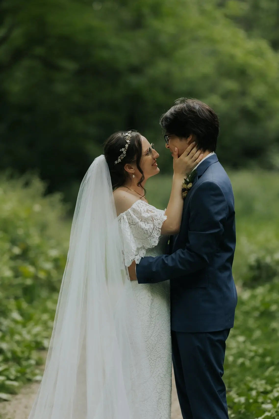 Bride and groom embracing in a garden during their wedding.