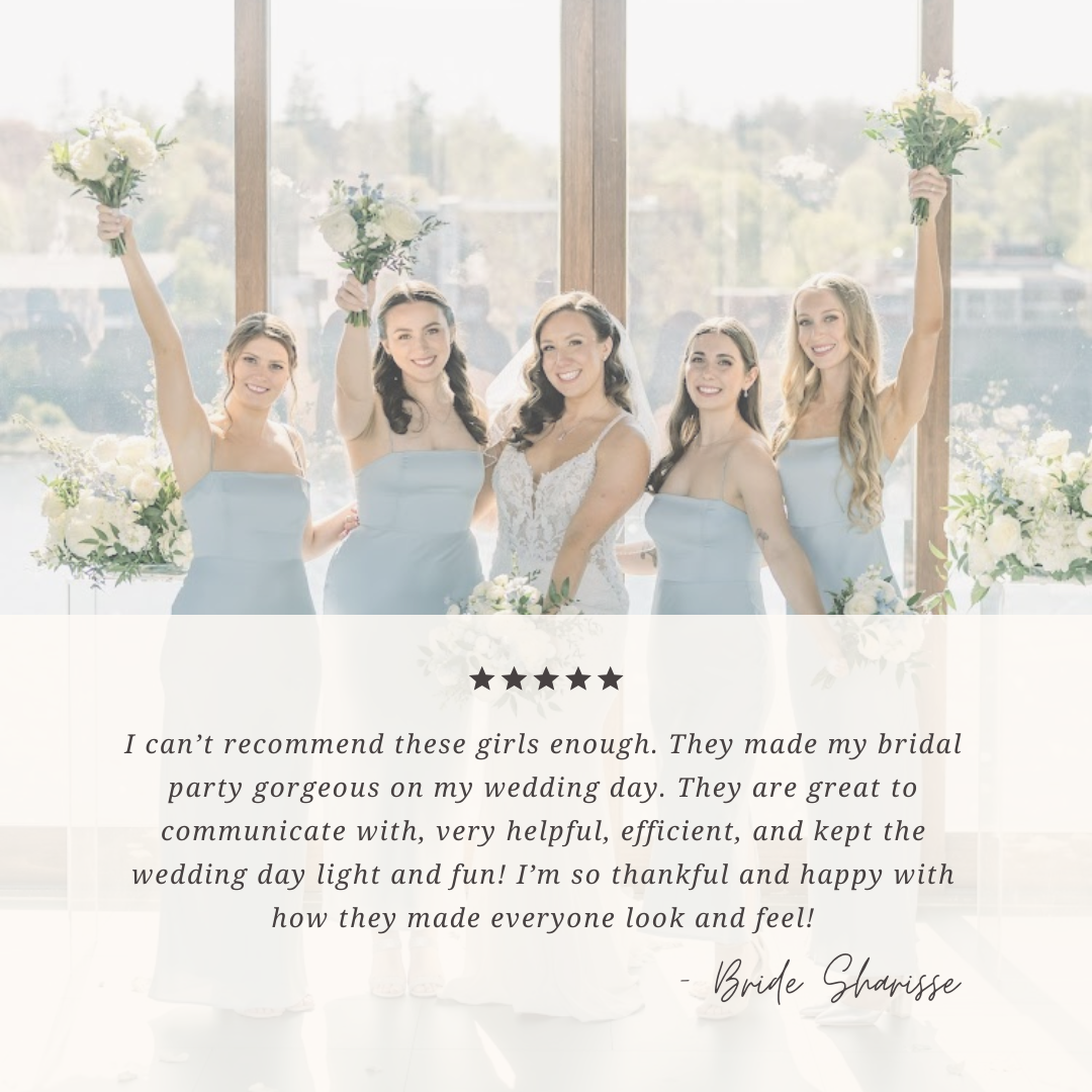 A bride with four bridesmaids holding bouquets, smiling at a wedding celebration in a bright, airy venue with large windows and outdoor scenery visible.