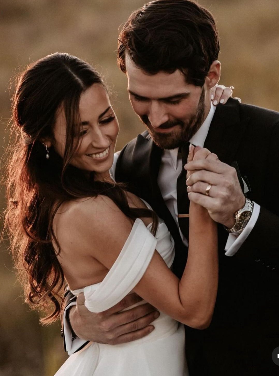 Bride and groom smiling and dancing at their wedding, close-up.
